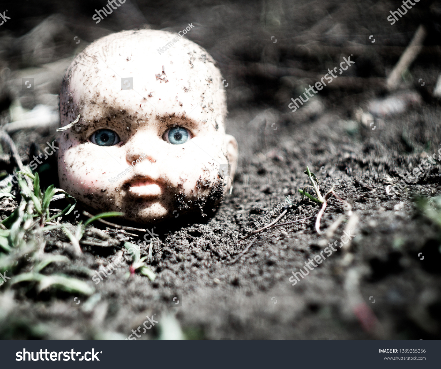 Old broken scary doll head on a ground in abandoned village. #1389265256