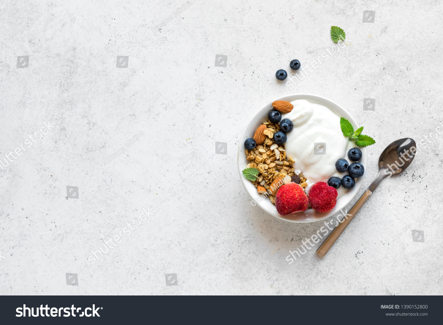 Granola with yogurt and berries for healthy breakfast. Bowl of greek yogurt with granola, almonds, blueberries and strawberries, top view, copy space. #1390152800
