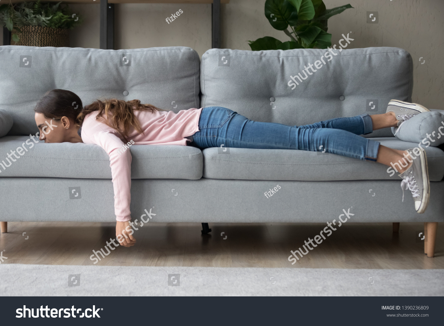 Full length of girl lying rest at home in living room buried her face in couch feels exhaustion having day nap lack of energy after party sleepless night or overworked, too tired no motivation concept #1390236809