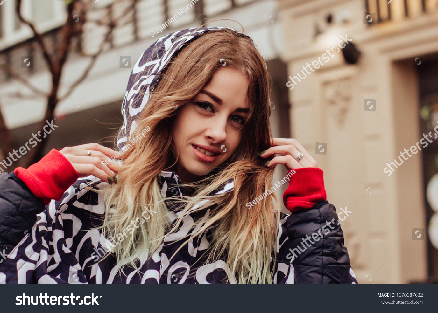 Portrait of a young beautiful woman in a raincoat, walking and dancing in the rain #1390387682