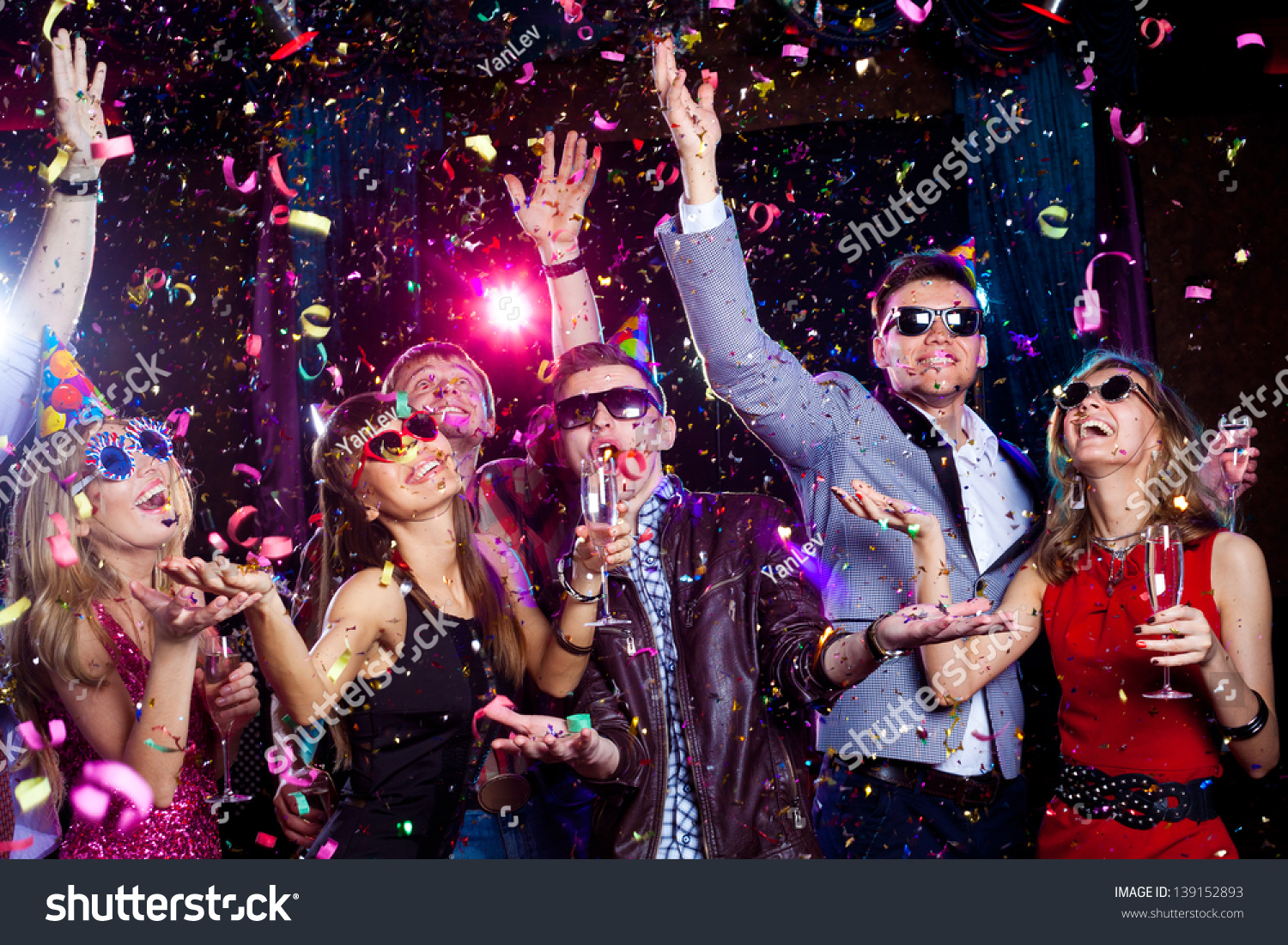 Cheerful young people showered with confetti on a club party. #139152893