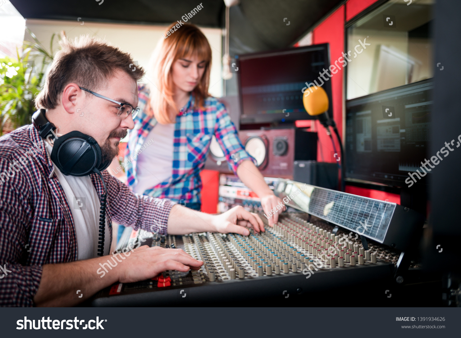 Music producer and musician in recording studio using soundboard for mixing sound #1391934626