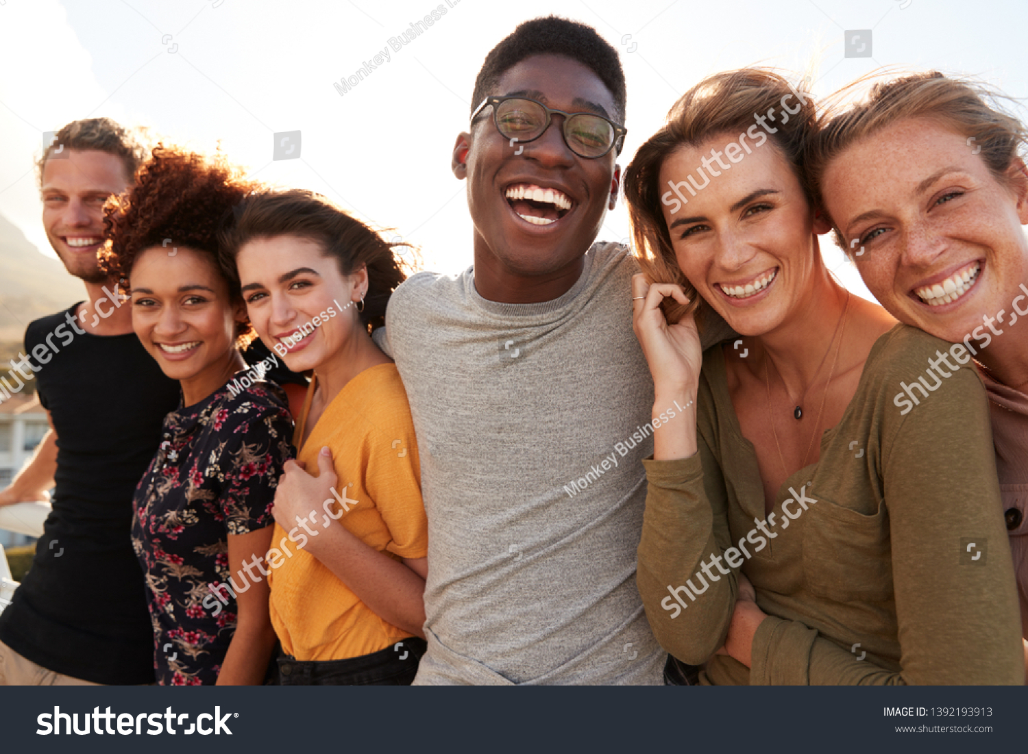 Portrait Of Smiling Young Friends Walking Outdoors Together #1392193913