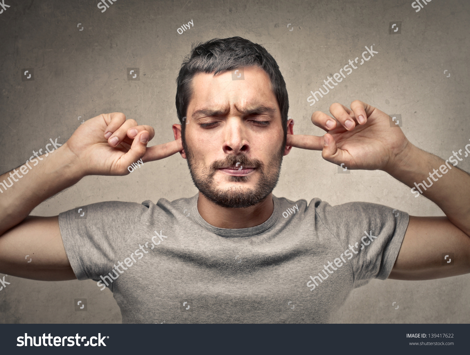 portrait of young man holds his hands over his ears not to hear #139417622