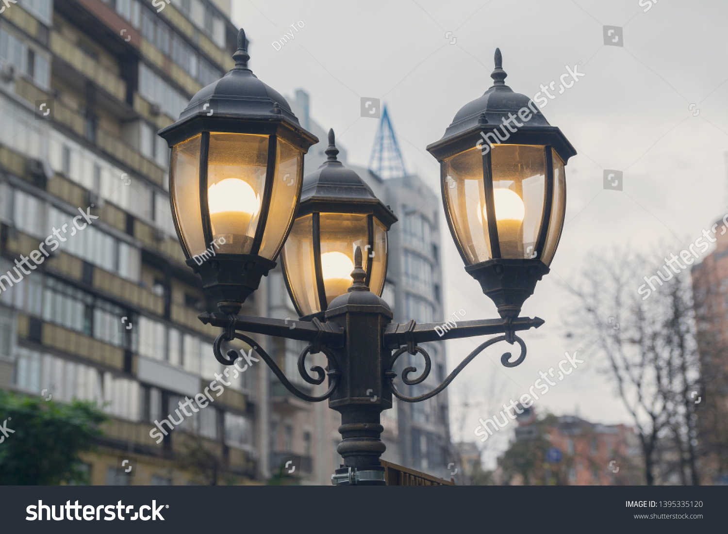 Electric light pole lantern on a city street with two bulb lamps and forged metal retro style #1395335120