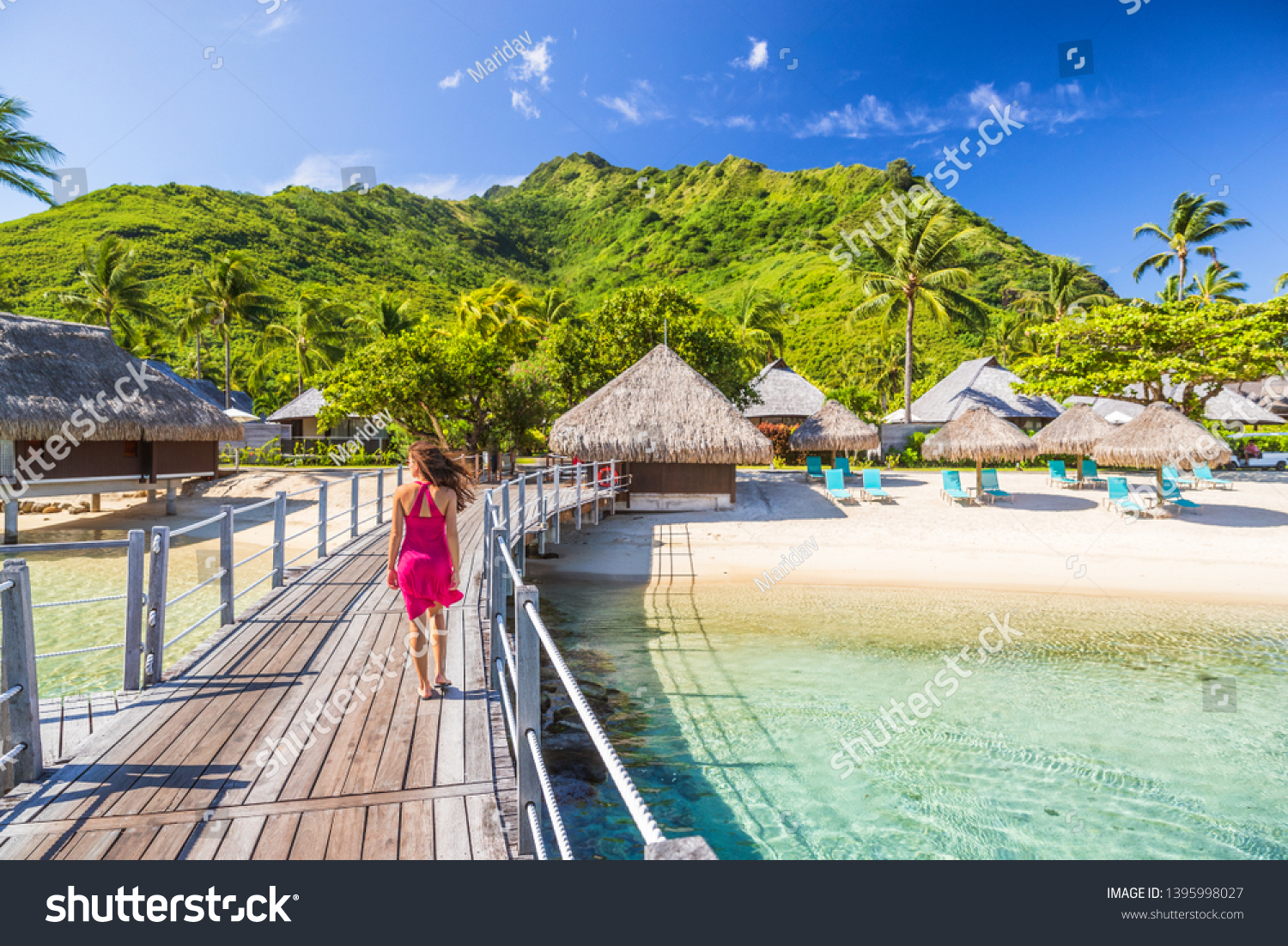 Overwater bungalow hotel resort in Tahiti, Moorea island. Person on holiday relaxing at French polynesia luxury destination. #1395998027