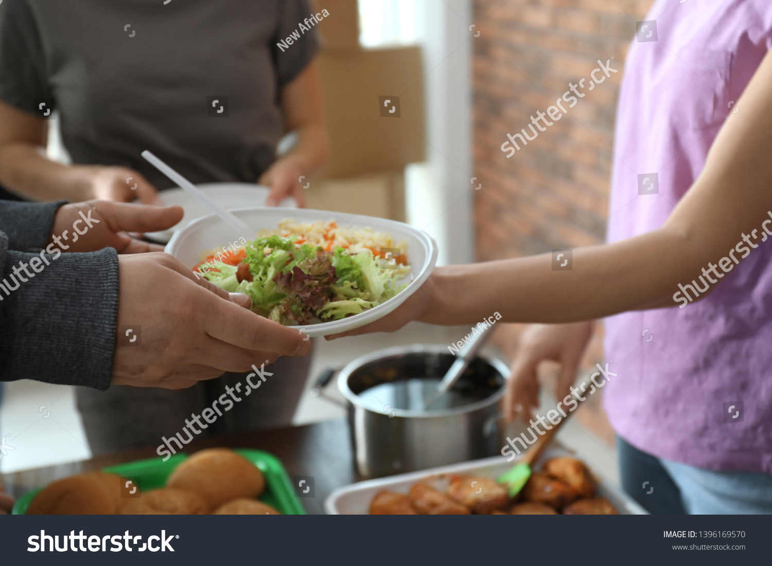 Poor man receiving food from volunteer indoors, closeup #1396169570