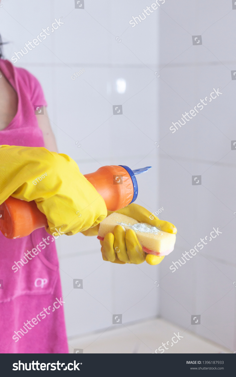 Young woman equipped with chemical cleaner bottle and sponge. Housekeeping and cleaning concept. Women preparing to clean up bathroom #1396187933