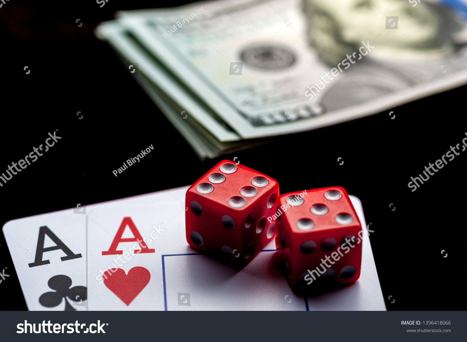 Close-up - Two aces, playing cards, red gaming dices and Stack of american dollars on black table. Casino, gambling game chance concept #1396418066
