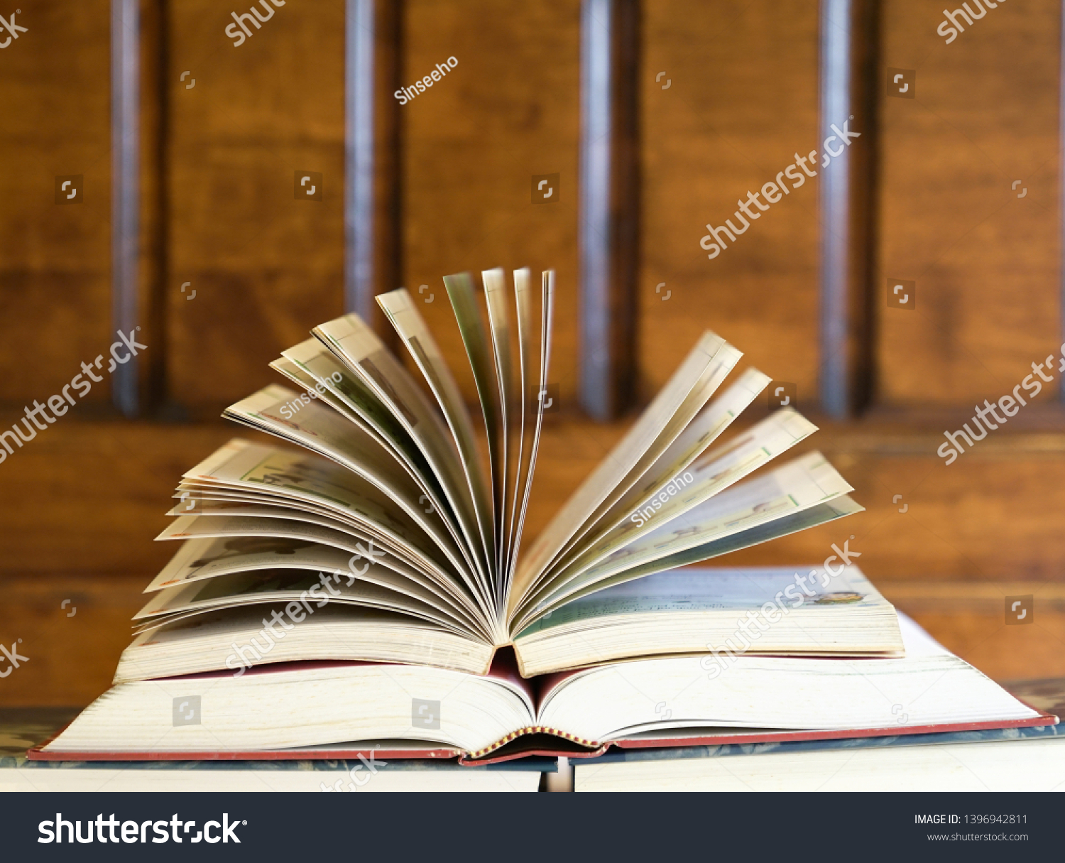 Open textbook on top of books with wood background, an education concept #1396942811