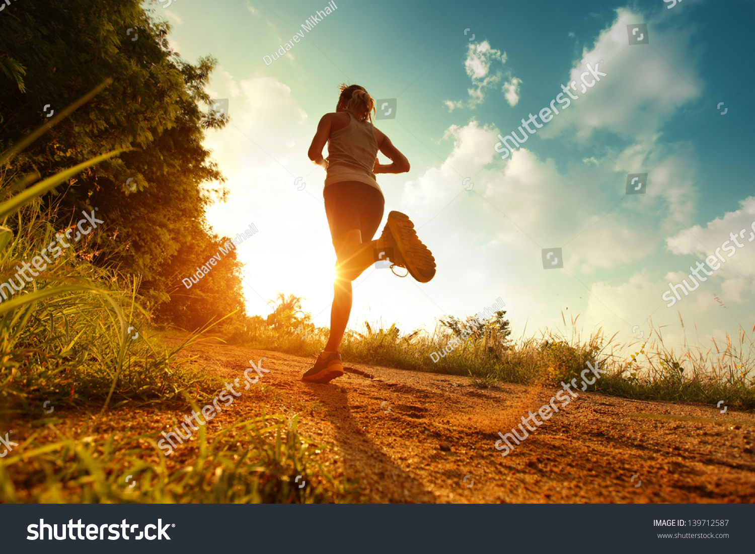 Young lady running on a rural road during sunset #139712587