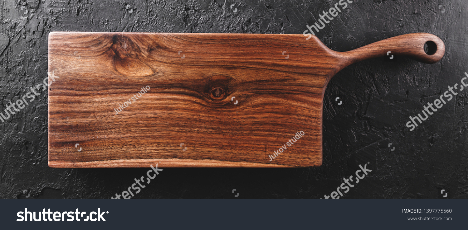 Chopping cutting board on dark stone background. Wooden texture. Top view, toning #1397775560