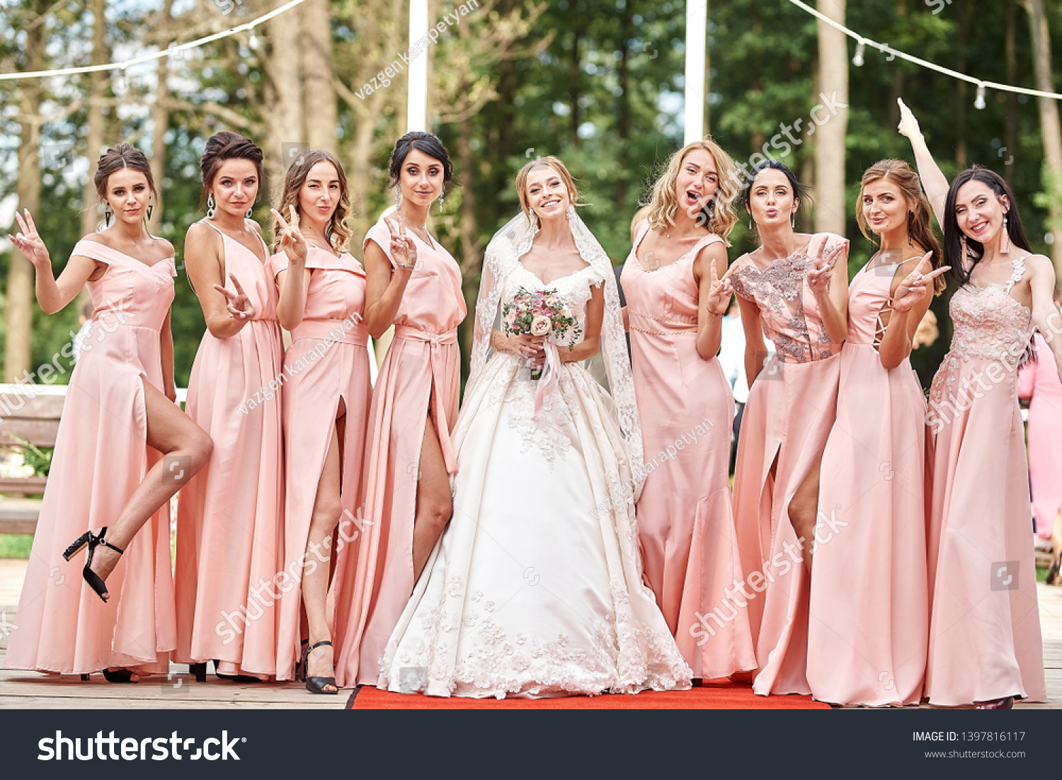 Beautiful bride and bridesmaids posing on the park on the wedding day. Bridesmaids dresses. Portrait of the bride and bridesmaids.Wedding day.  #1397816117
