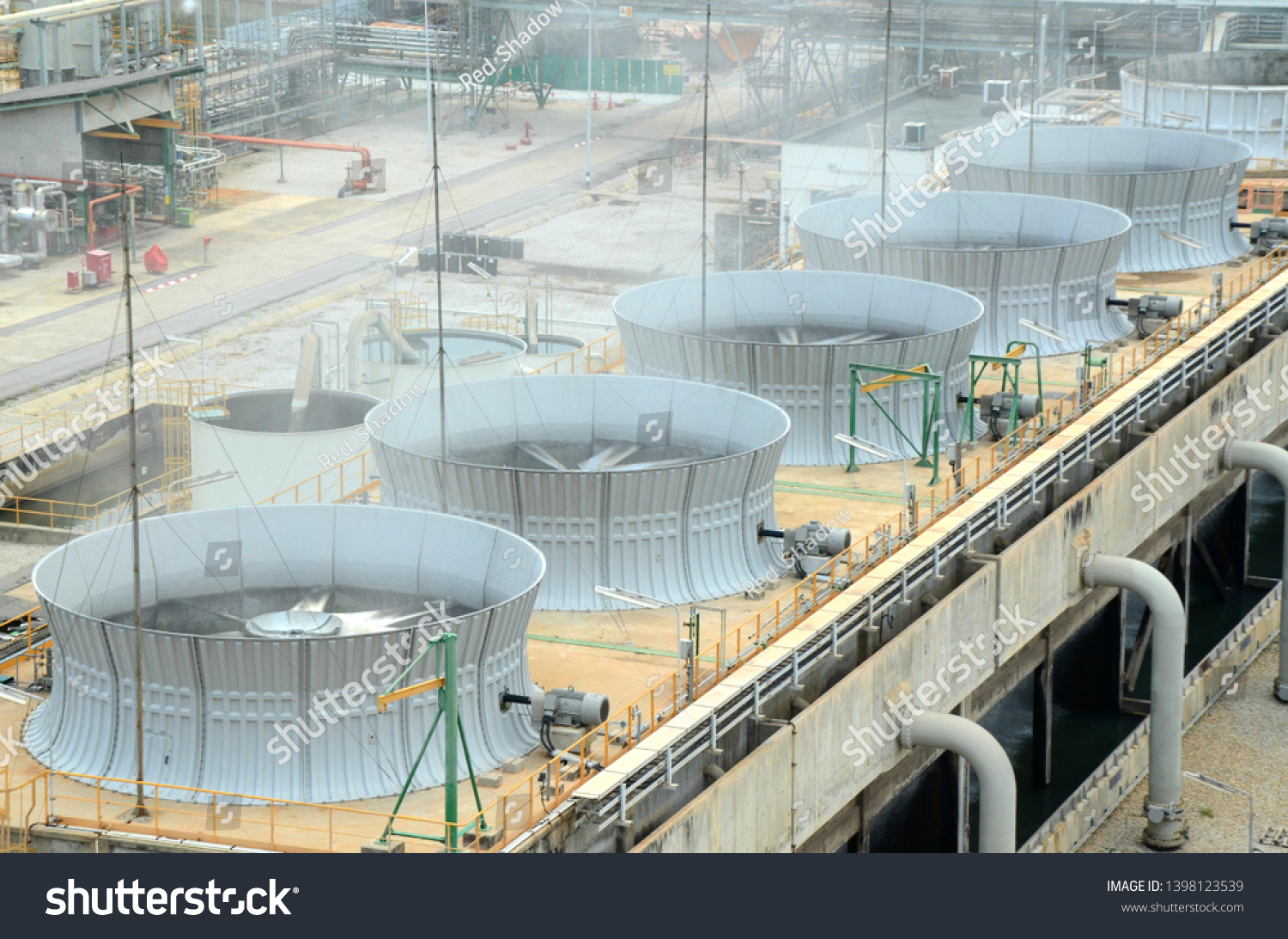 May 2019 in Rayong Thailand. cooling tower and cooling fan blowing steam on the air in chemical plant,  refinery plant, oil and gas plant during operation. #1398123539