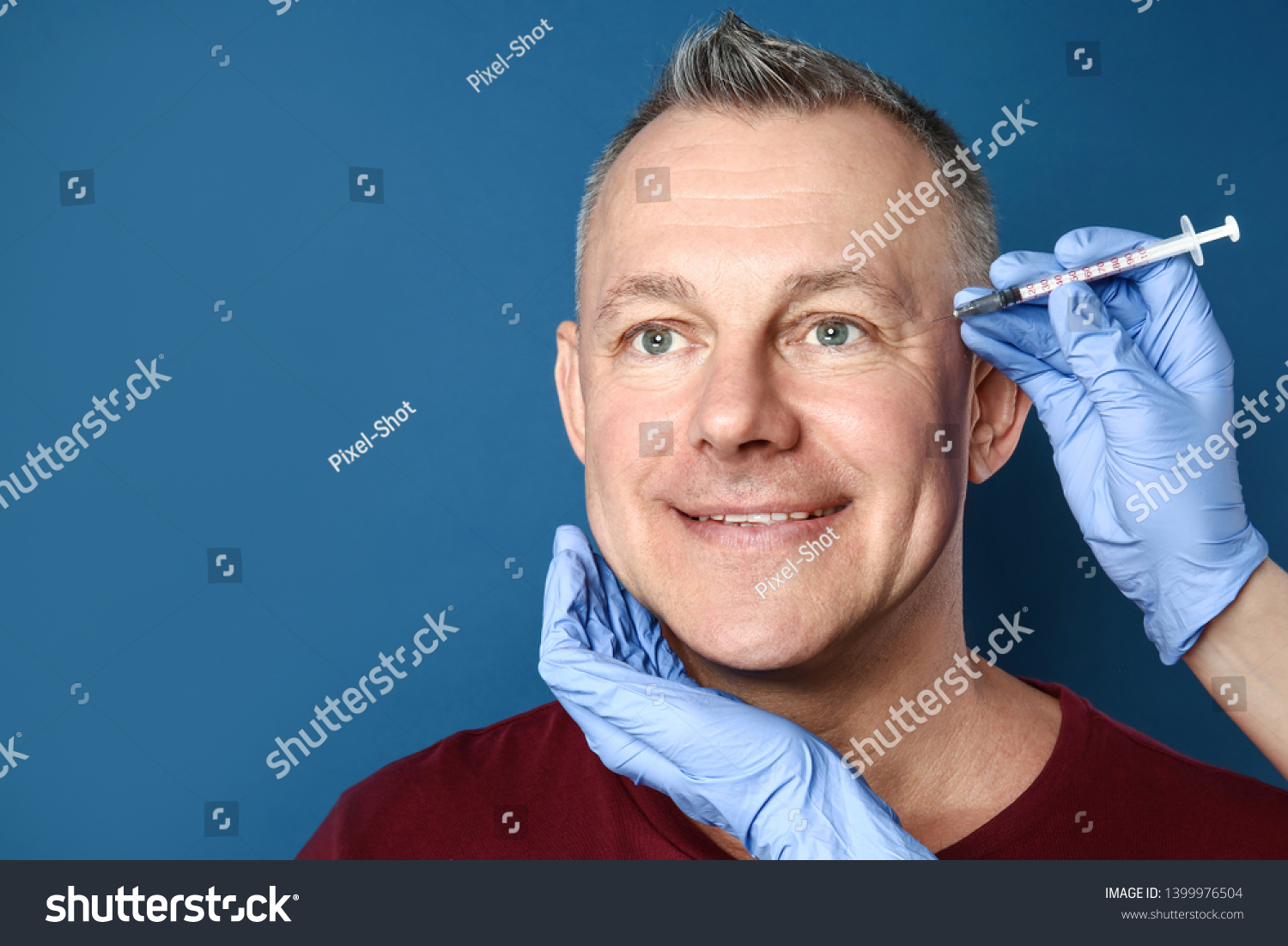 Middle-aged man and hands holding syringe for anti-aging injections on color background #1399976504