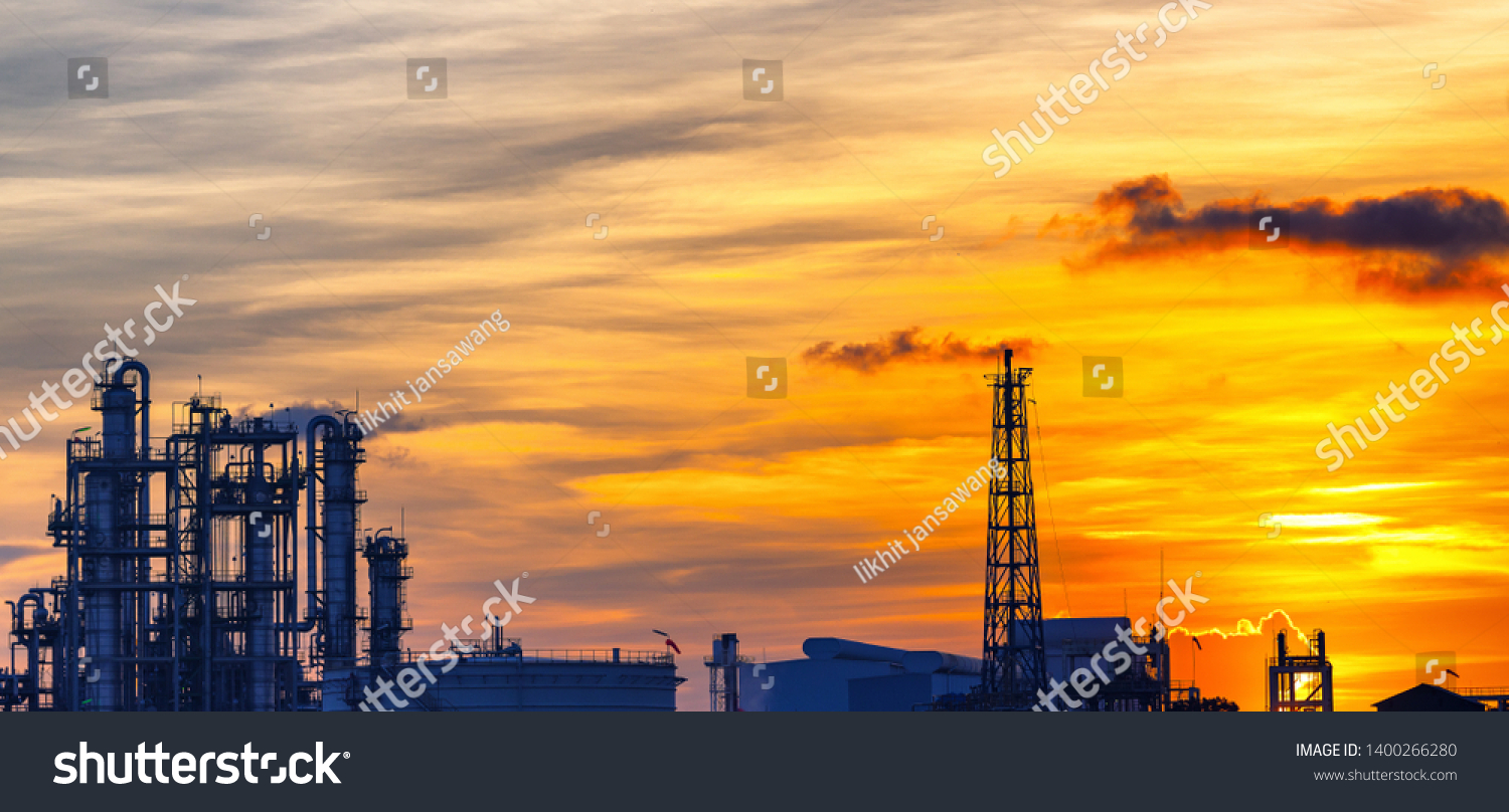 Petrochemical plant or oil and gas refinery industry with smoke stacks in silhouette image on sky sunset background #1400266280