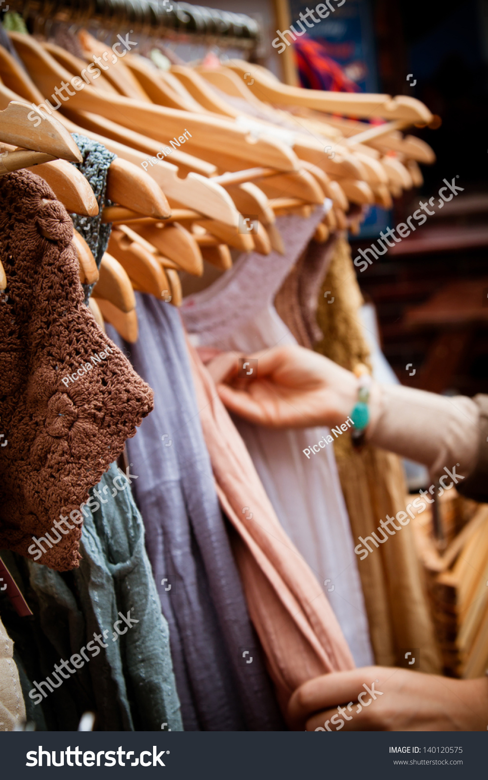 Recession bargains: rack of second-hand dresses for sale at market. Portrait orientation. #140120575