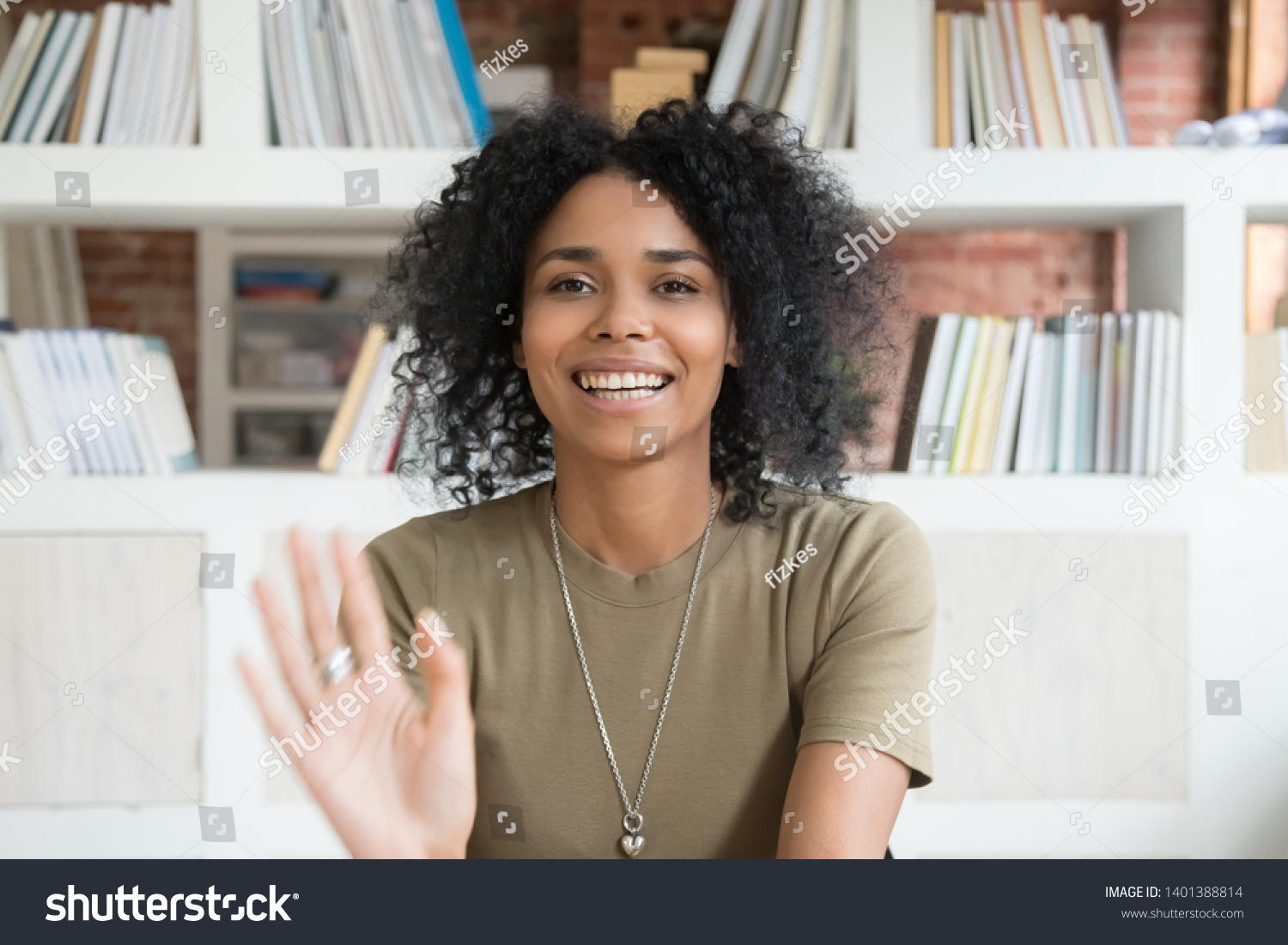 Happy african American millennial woman wave talk on webcam or having conversation, smiling positive black female blogger shoot record new blog or vlog, greeting say hello to followers audience #1401388814