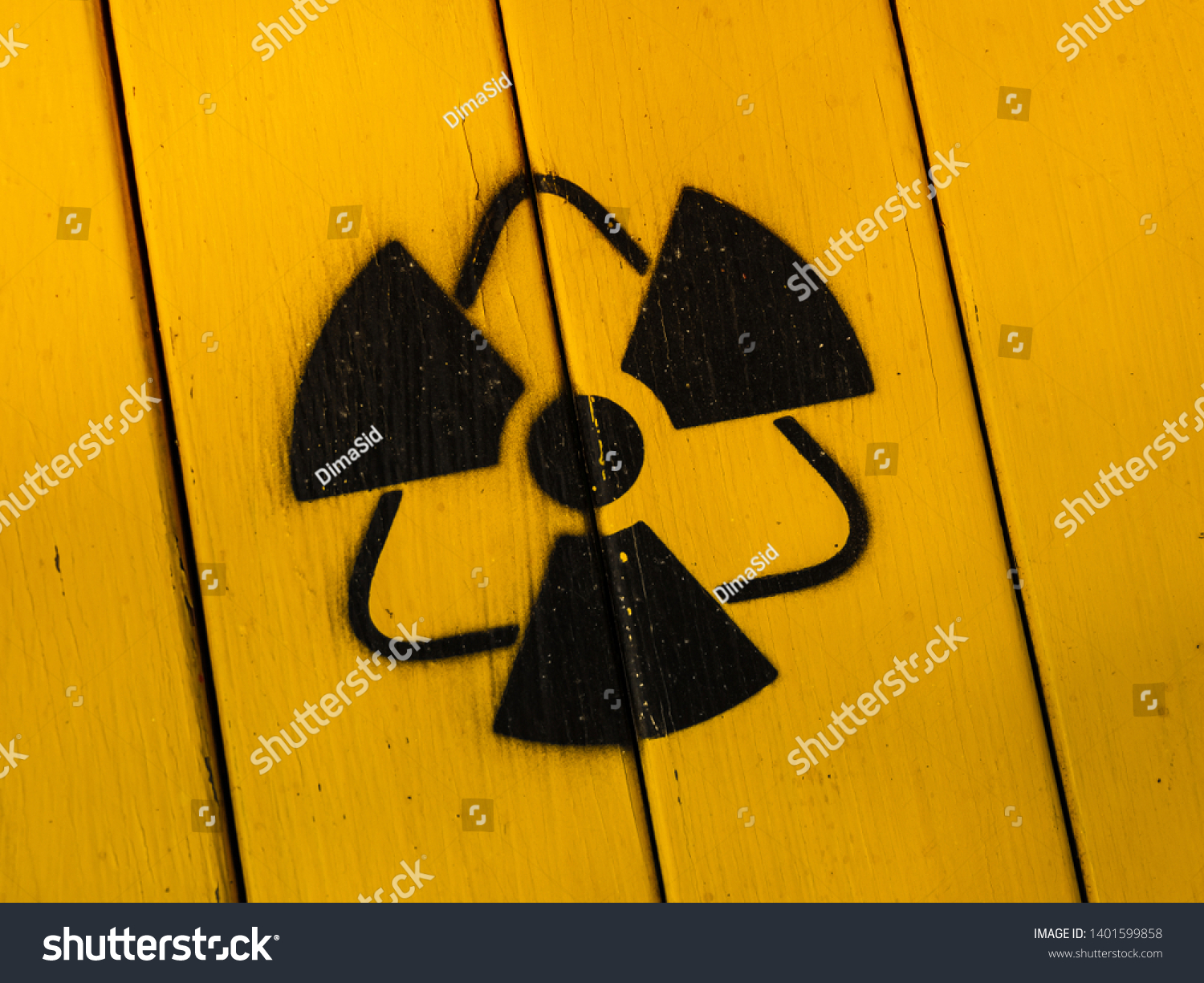 Radioactivity sign, close-up. Sign of radiation on a yellow wooden board. Radioactive sign - symbol of radiation. Yellow and black radioactive hazard, ionizing radiation, nuclear danger warning symbol #1401599858