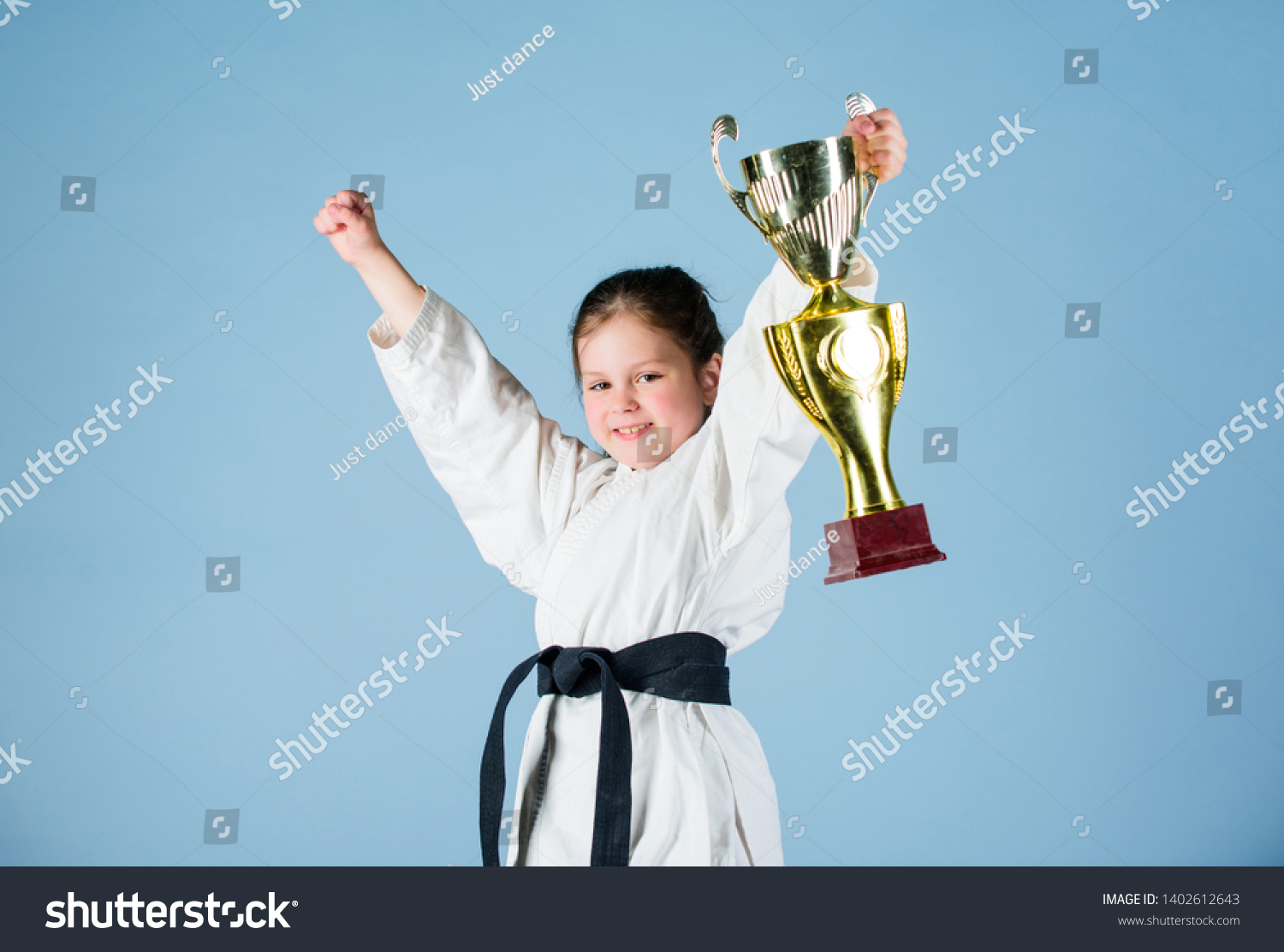 Karate fighter child. Karate sport concept. Self defence skills. Karate gives feeling of confidence. Strong and confident small kid. Victory and win. Girl little child in white kimono with belt. #1402612643