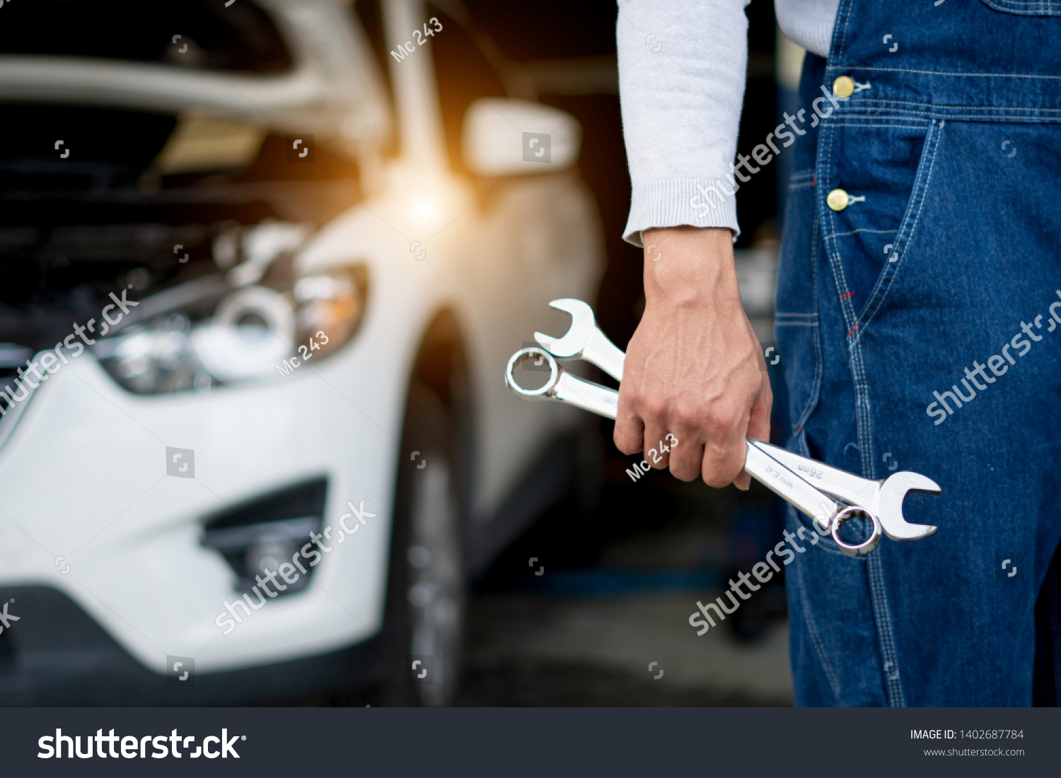 Hand of car mechanicrench with w. Auto repair garage. #1402687784