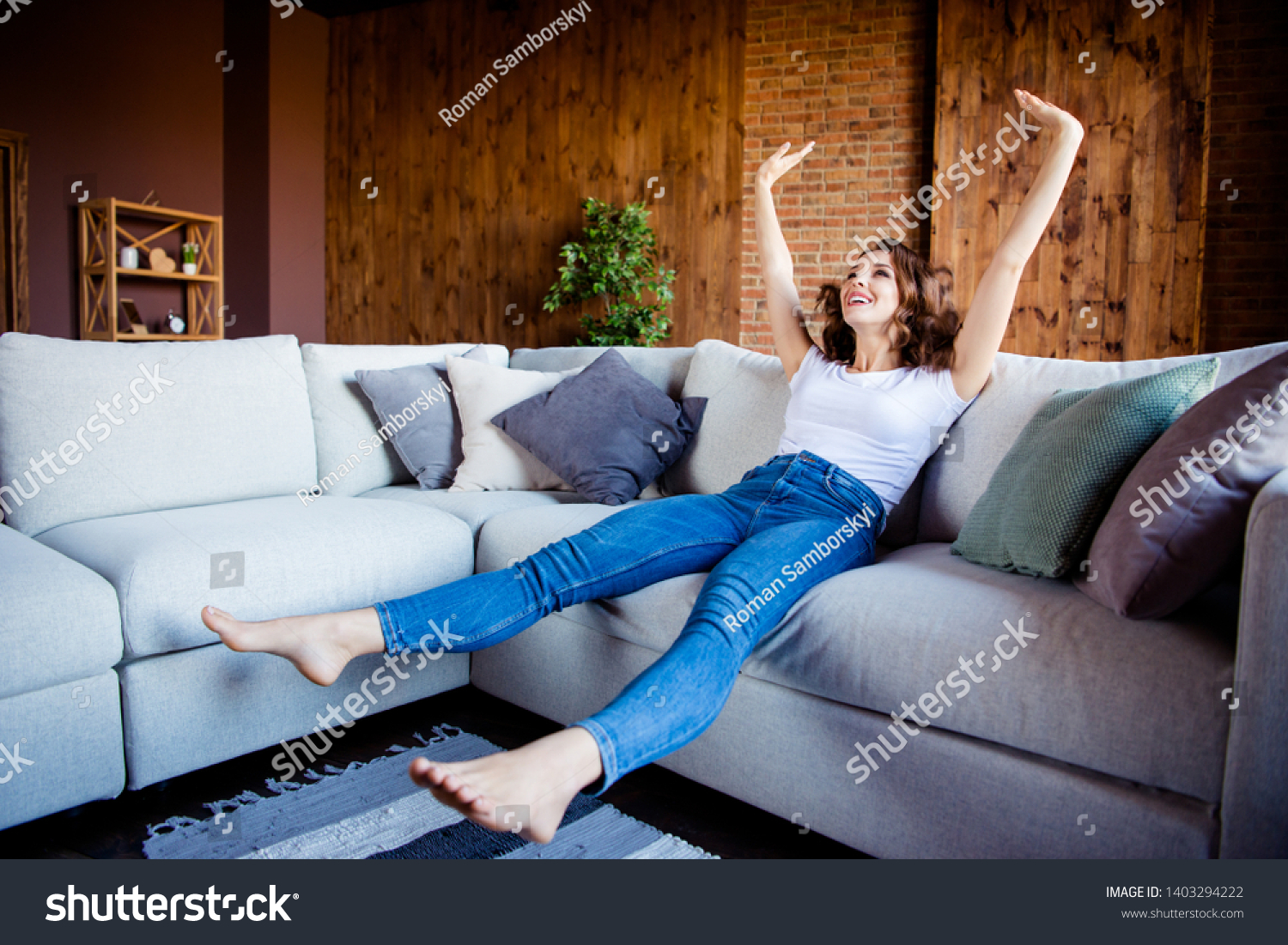 Full length body size view of her she nice attractive lovely charming cheerful cheery wavy-haired girl sitting on comfortable divan having fun time at industrial loft wooden brick style interior #1403294222