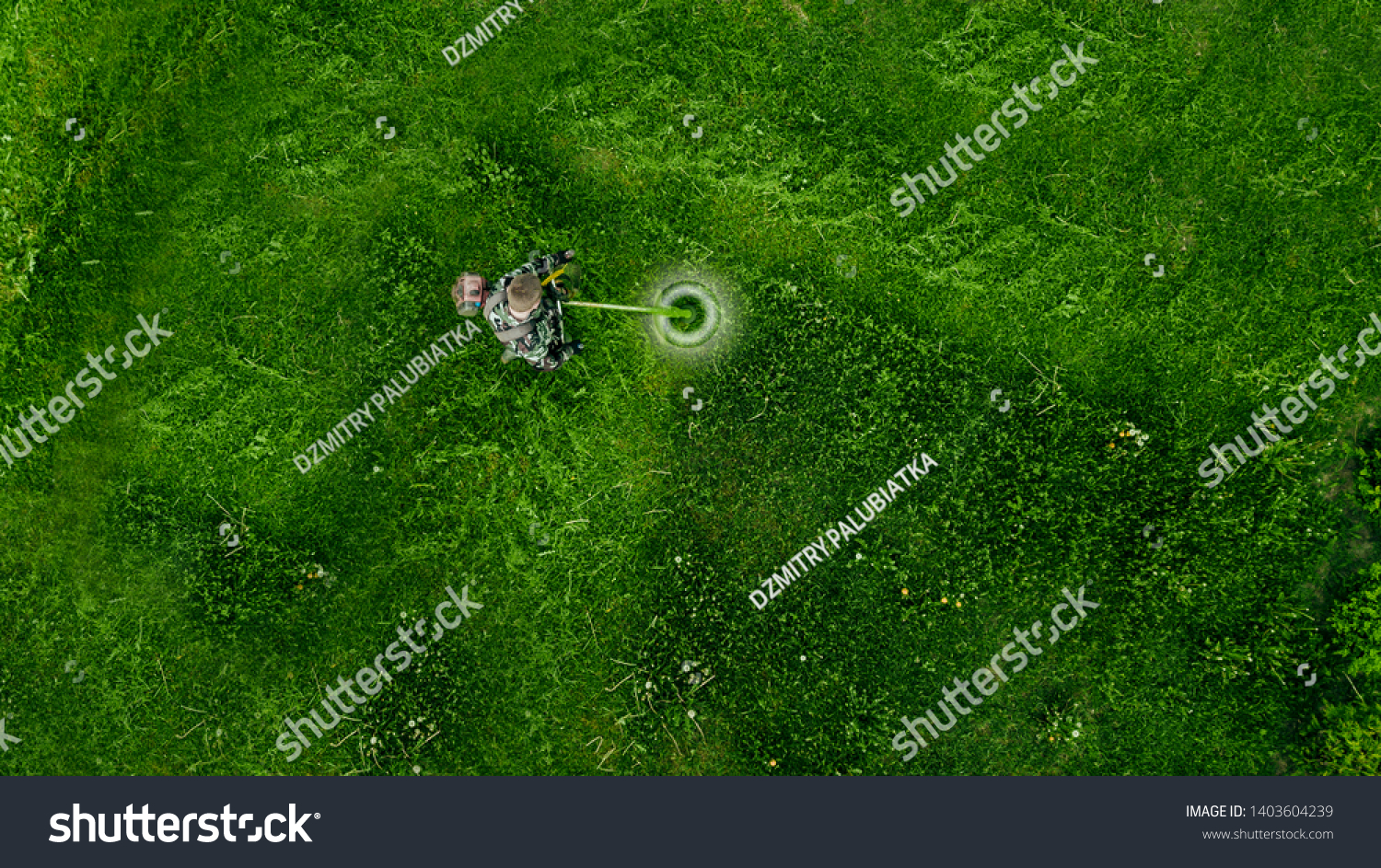 Top view man worker cutting grass with lawn mower.  #1403604239