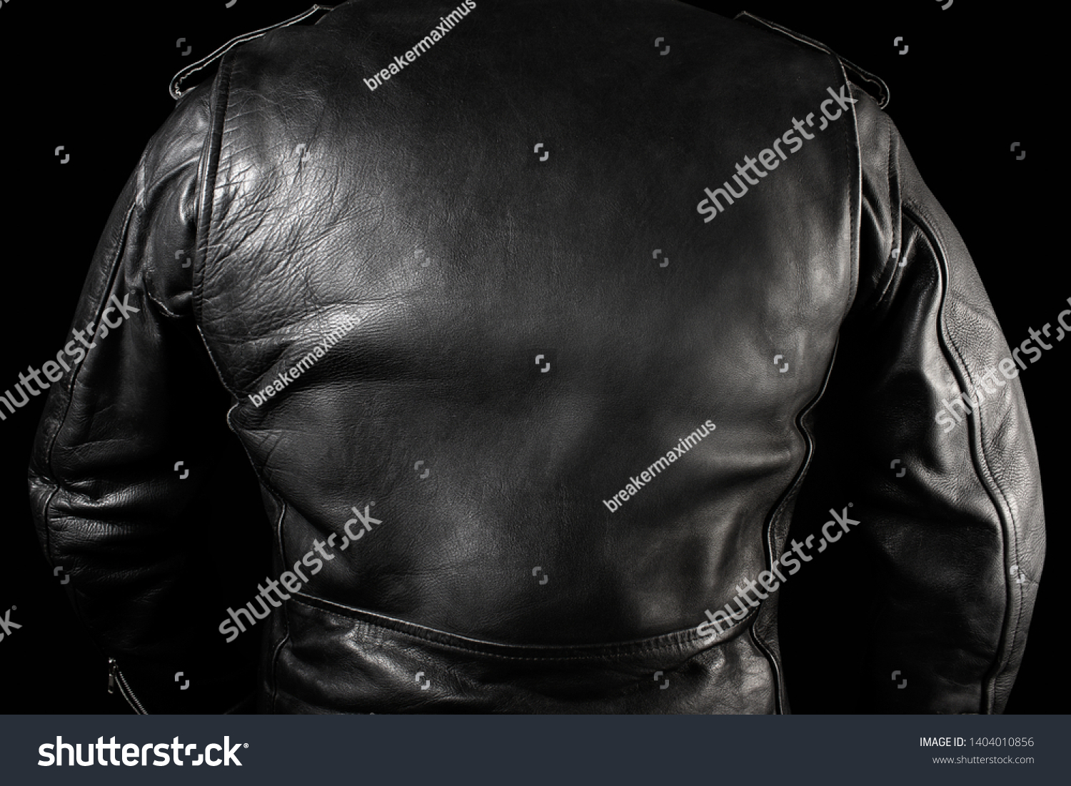 Photo of a man in black leather biker jacket standing on neon lightened night street background rear view. #1404010856