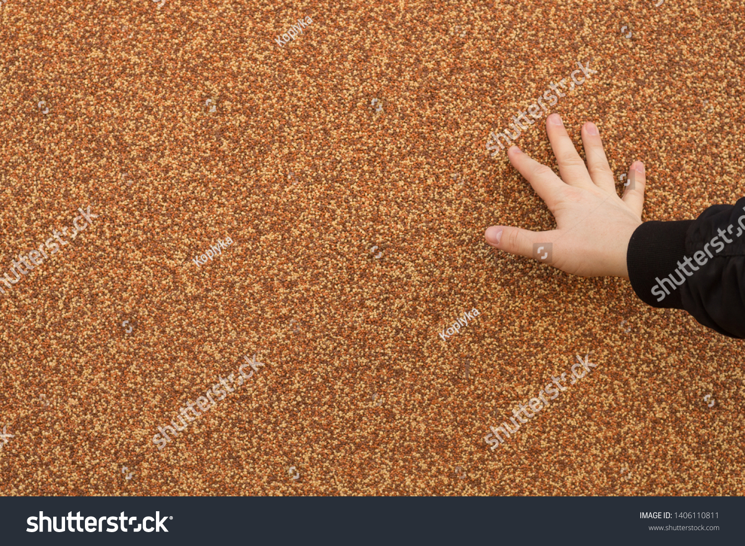 Background texture. An abstract image of a hand stretches and touches and touches the embossed rough wall surface covered with textured plaster from crushed multi-colored pebbles. Marble chips. #1406110811