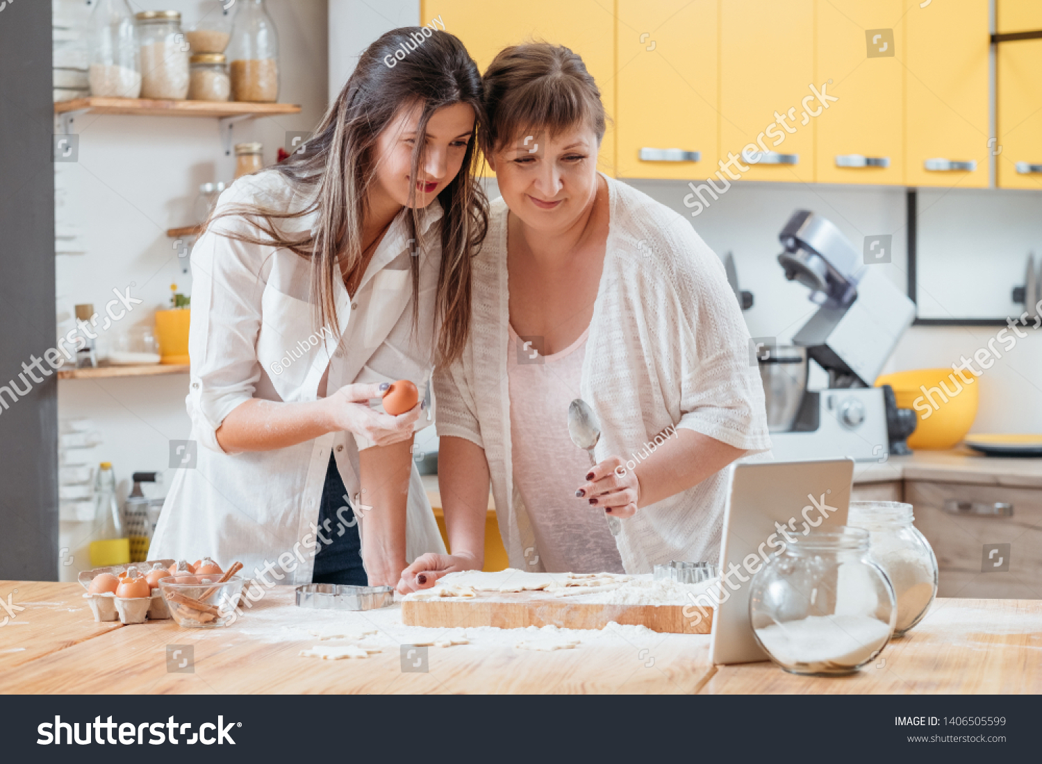 Online culinary class. Homemade bakery food and pastry. Mother and daughter watching food recipe tutorial video. #1406505599