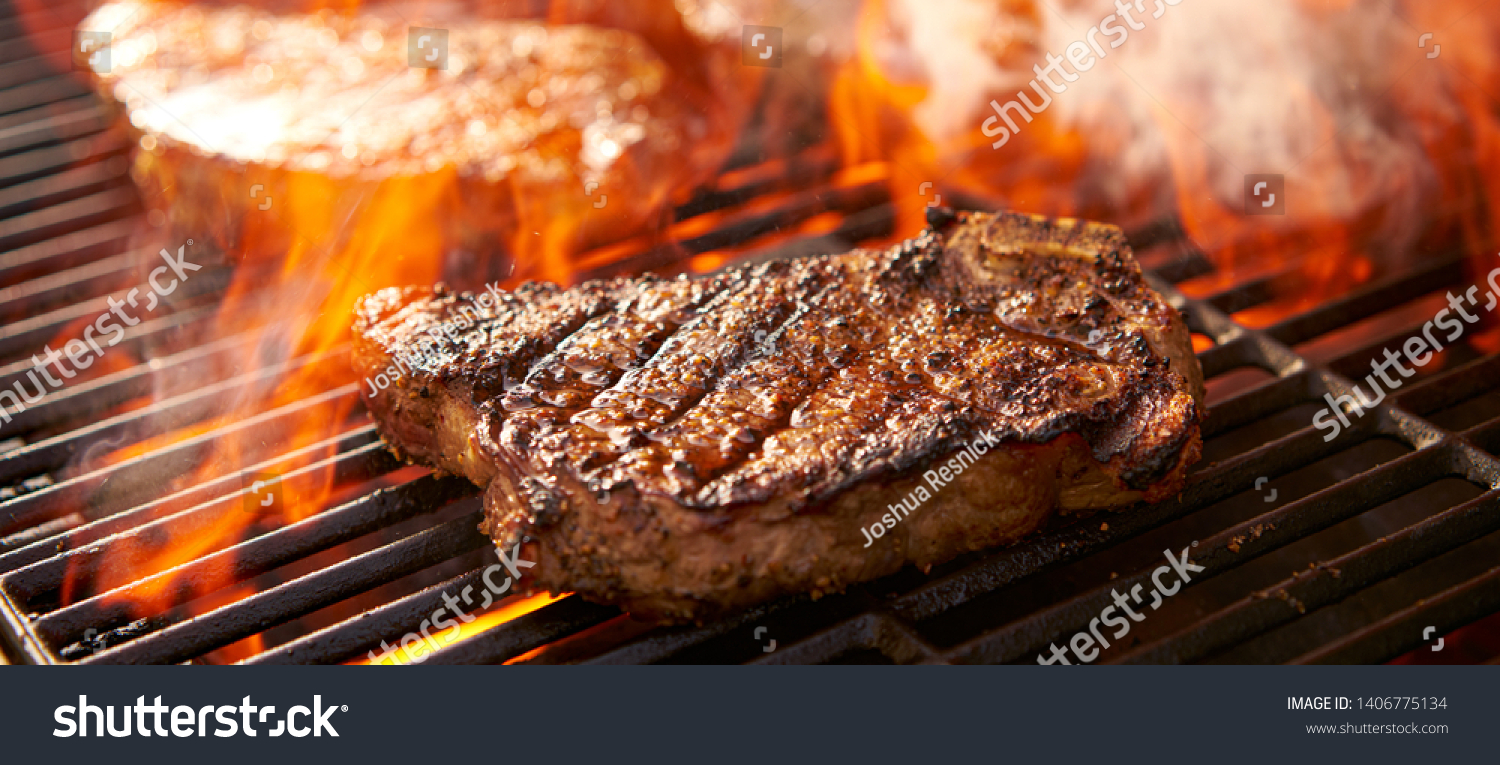 rib-eye steaks cooking on flaming grill panorama #1406775134