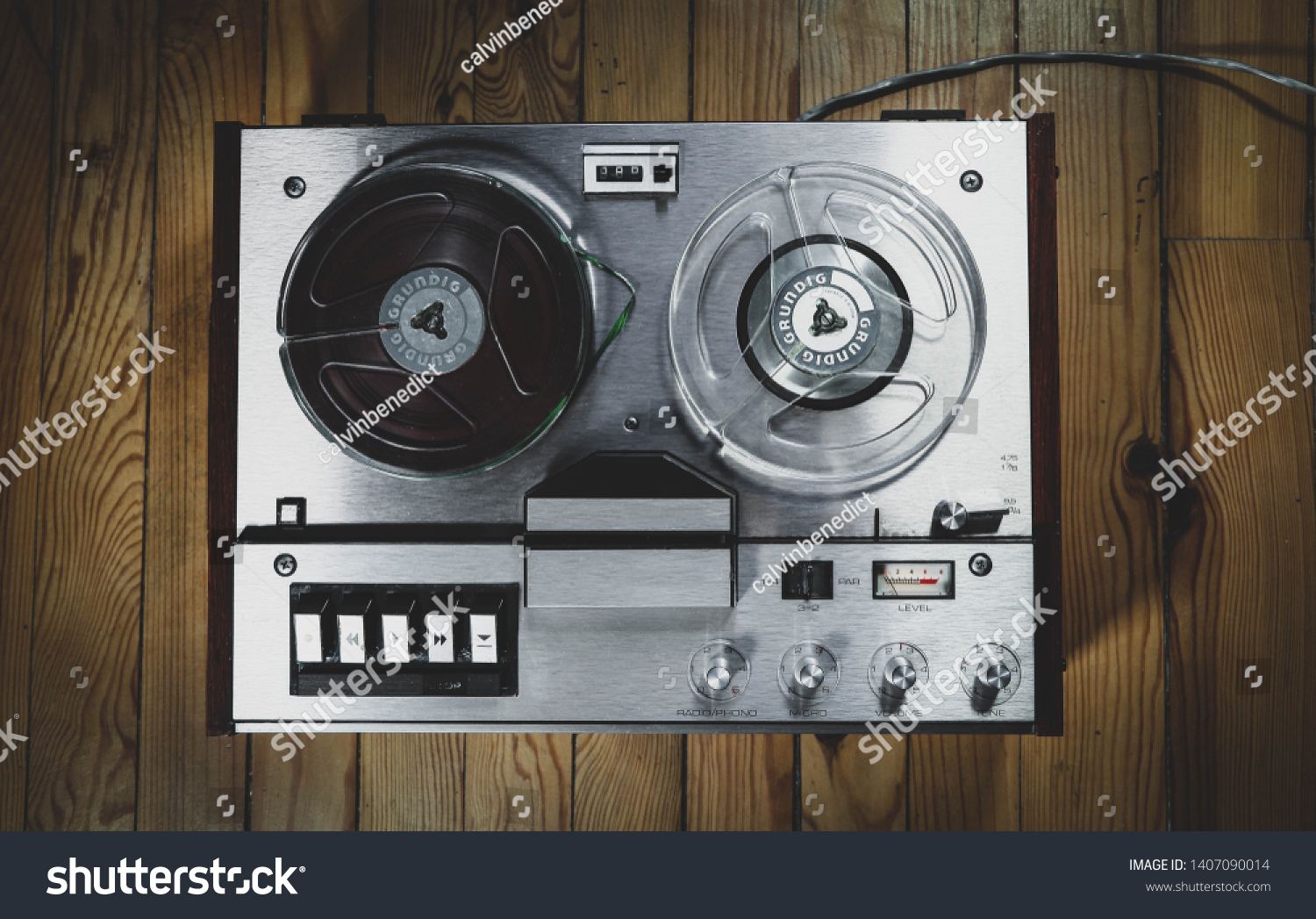 Vintage reel to reel tape recorder on a wooden floor #1407090014