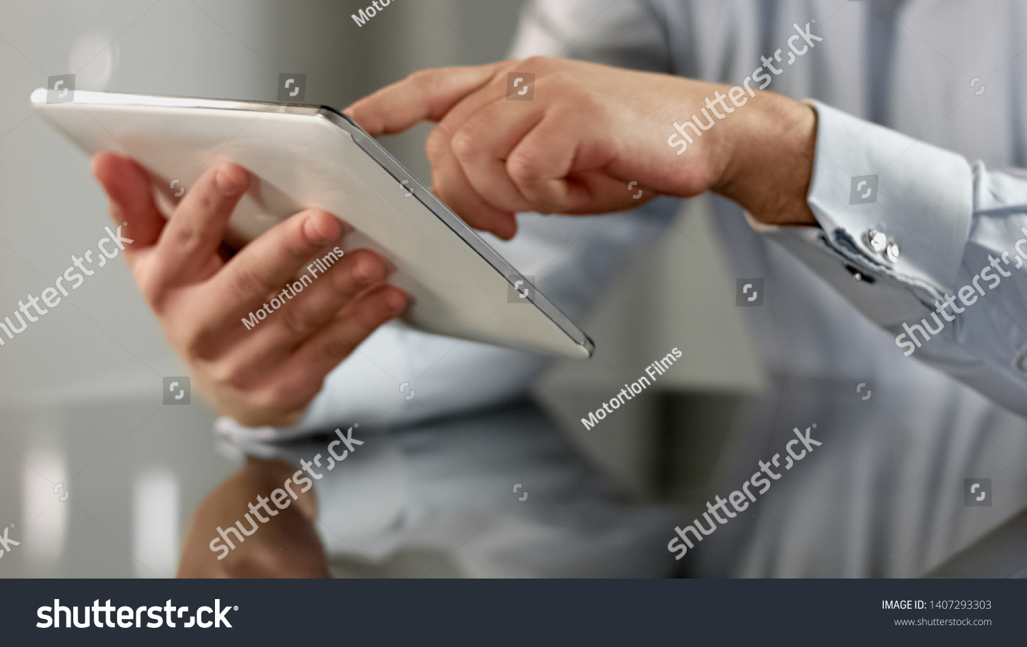 Businessman hands scrolling news application on tablet, touchscreen device #1407293303