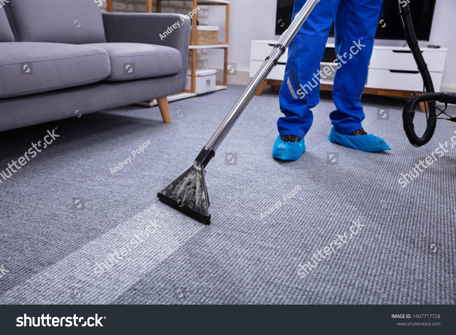 Low Section Of A Male Janitor Cleaning Carpet With Vacuum Cleaning In The Living Room #1407717728