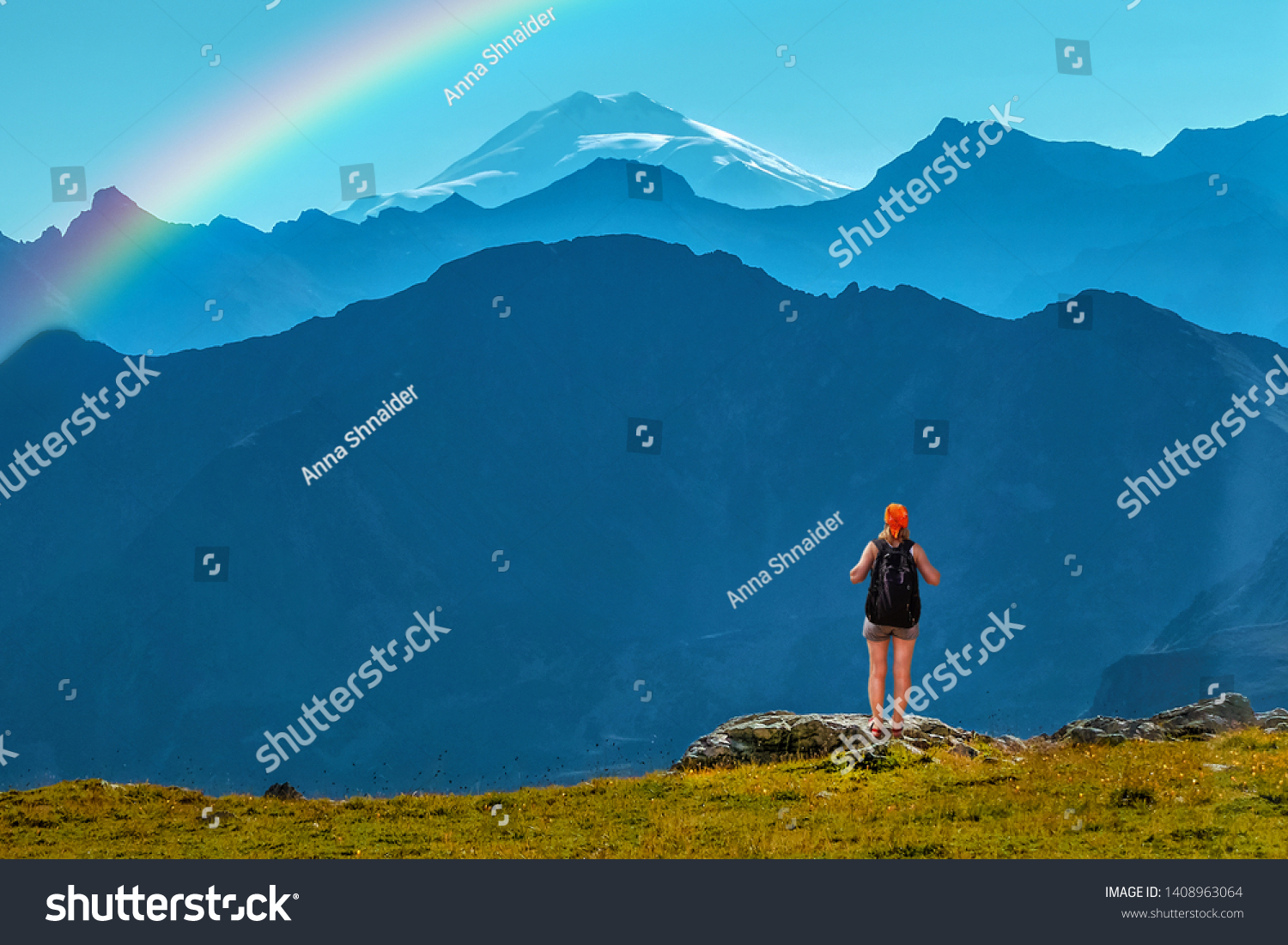 Girl traveler with backpack stands on a stone back to the viewer. She looks at the snow-capped top. Picturesque cloudless landscape with a rainbow. Wallpaper for concept of business thinking. #1408963064