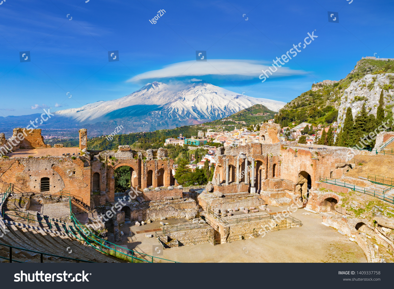 Ruins of Ancient Greek theatre in Taormina on background of Etna Volcano, Italy. Taormina located in Metropolitan City of Messina, on east coast of island of Sicily. #1409337758