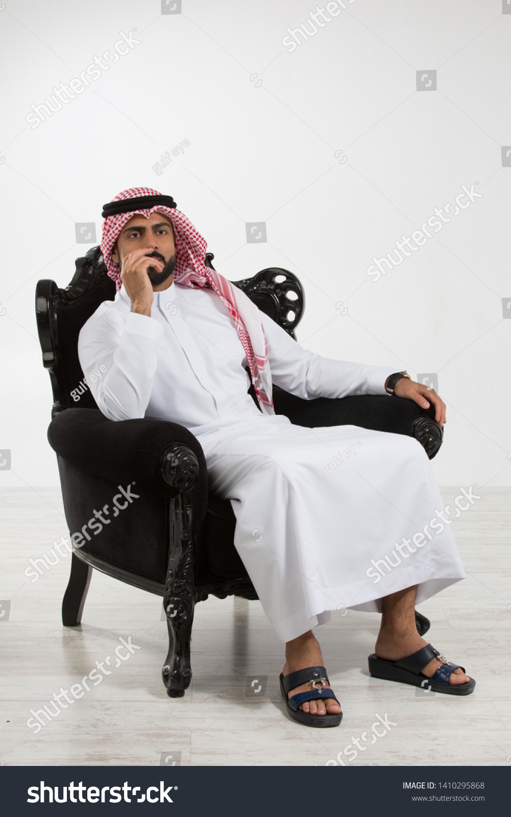Portrait of an arab man sitting down on a chair. #1410295868