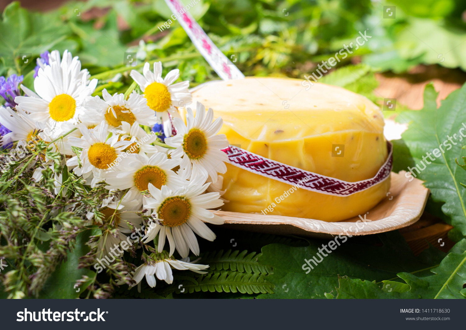 bouquet of daisies and cheese with fern and ribbon. symbolism of Latvia for Ligo holiday #1411718630