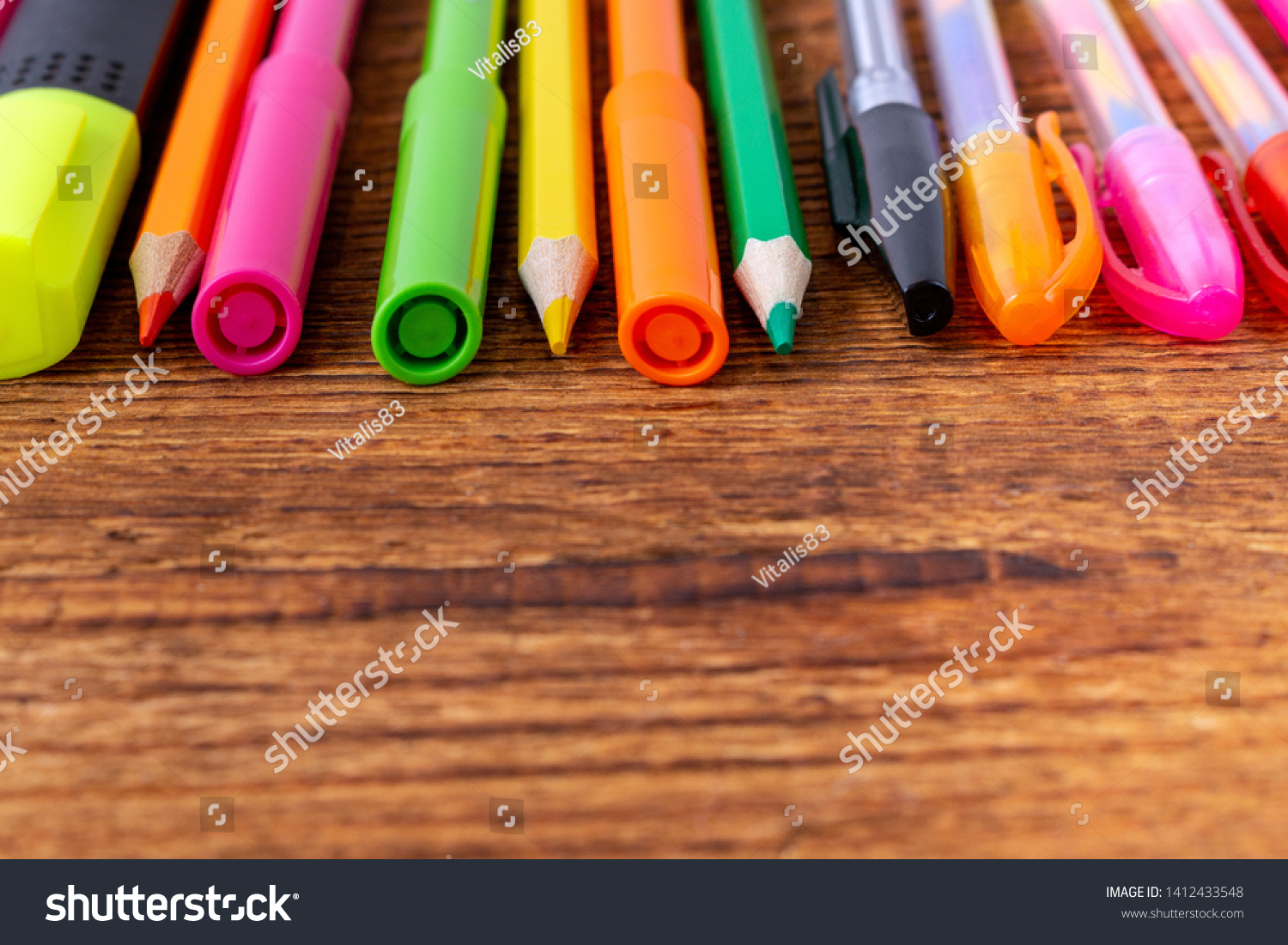 colorful pencils, markers and pens composition mock-up Back to school concept with stationery office supplies on a brown wooden background with copy space close-up #1412433548