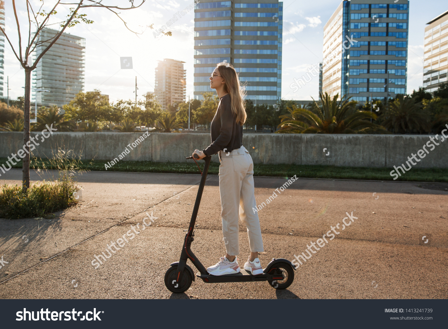 Young beautiful woman riding an electric scooter to work, modern girl, new generation, electric transport, ecology, ecological transport, sunset, electric skateboard, 4k #1413241739