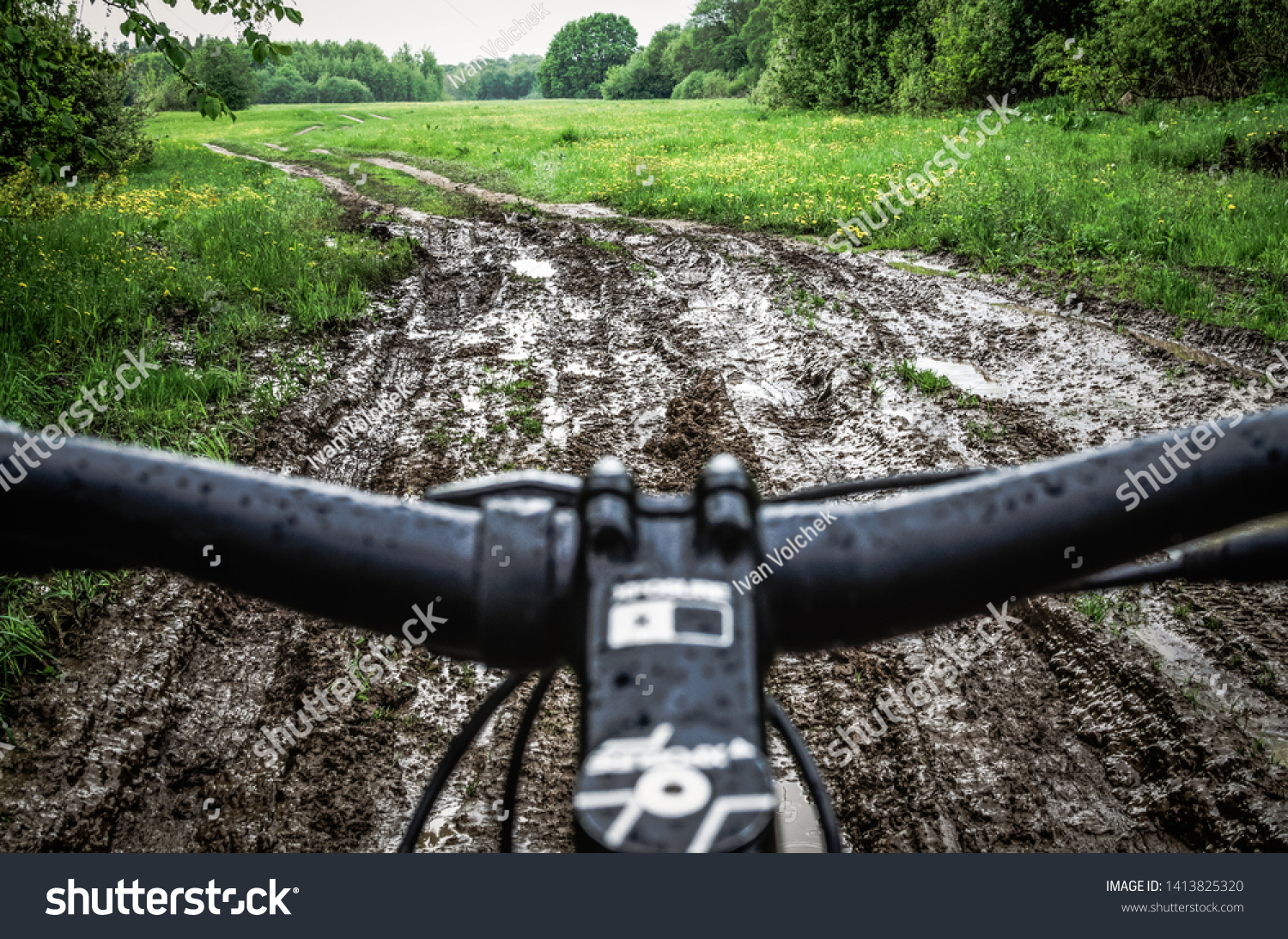 Riding a bike through the mud. Mountain Biker Riding Through A Dirty Puddle #1413825320