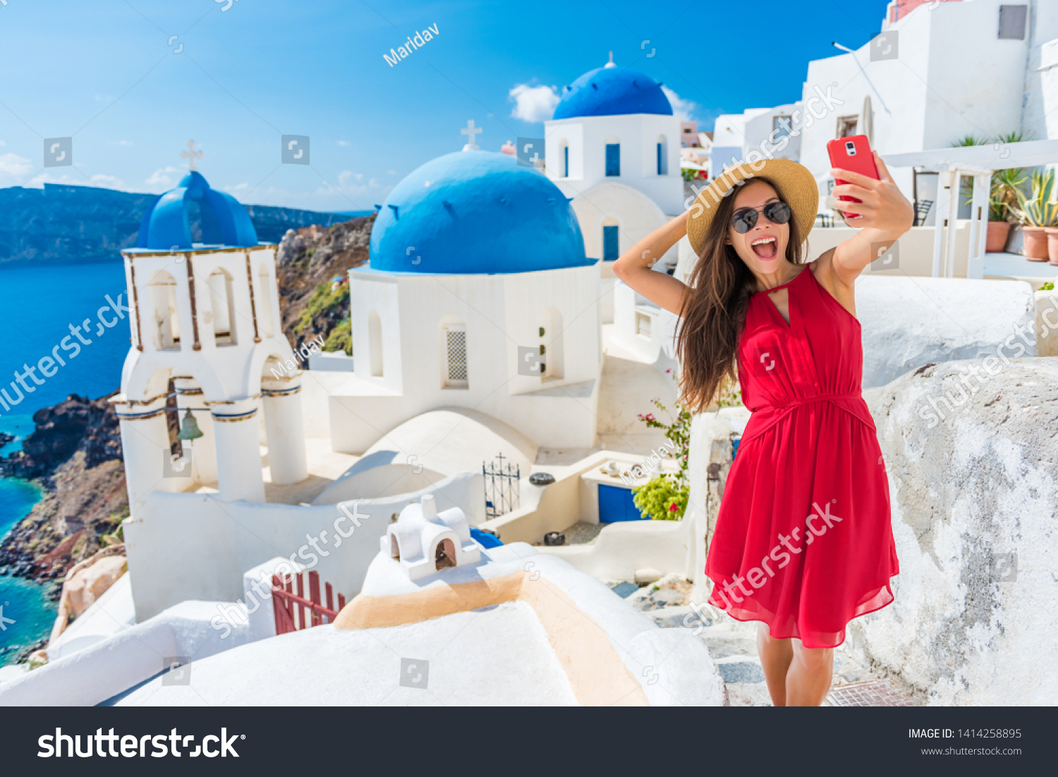 Santorini tourist girl on cruise holiday taking selfie photo with phone at famous three domes church, European tourism attraction in Greece. Asian woman on vacation. #1414258895