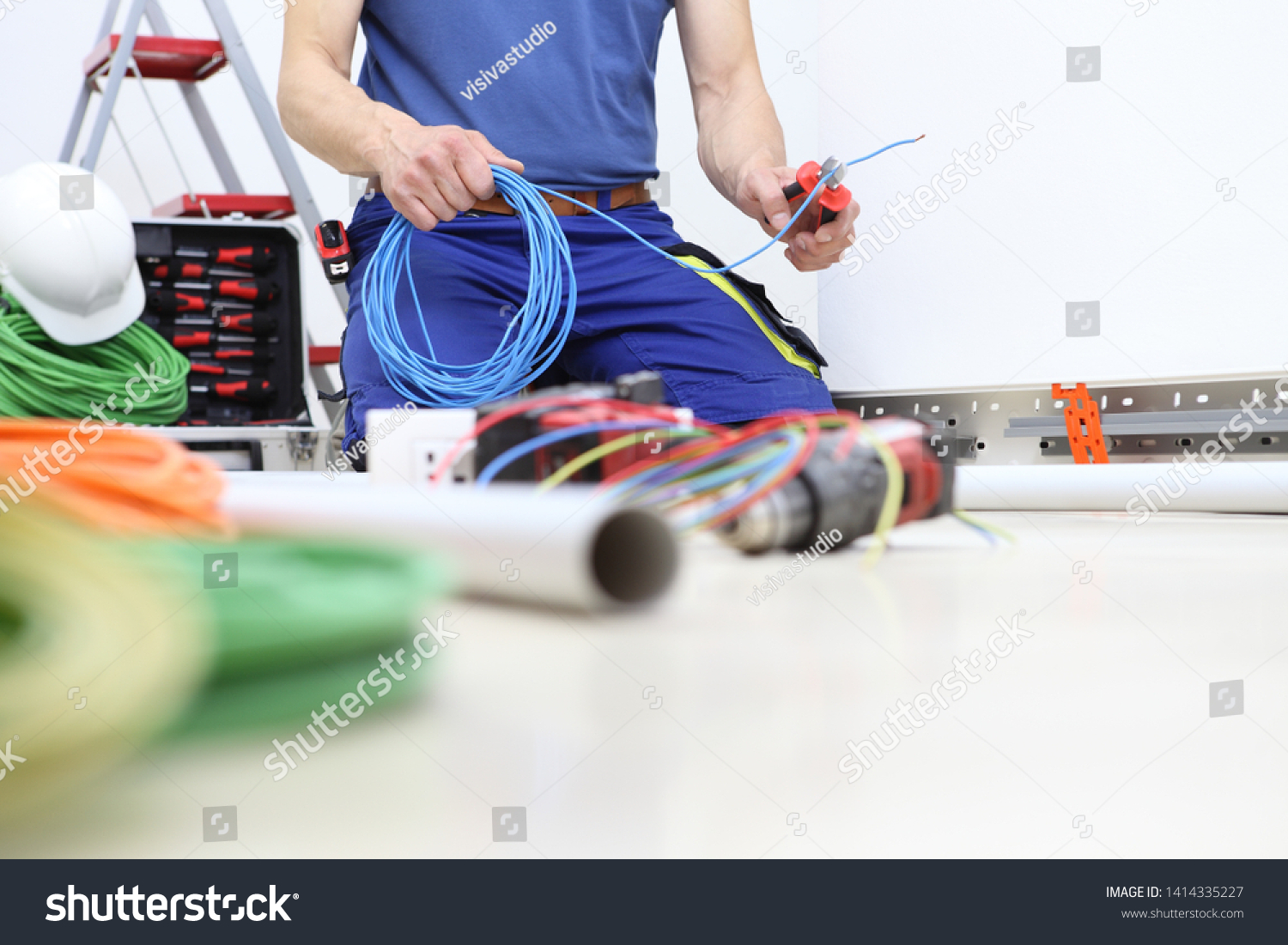 electrician at work with nippers in hand cut the electric cable, install electric circuits, electrical wiring #1414335227