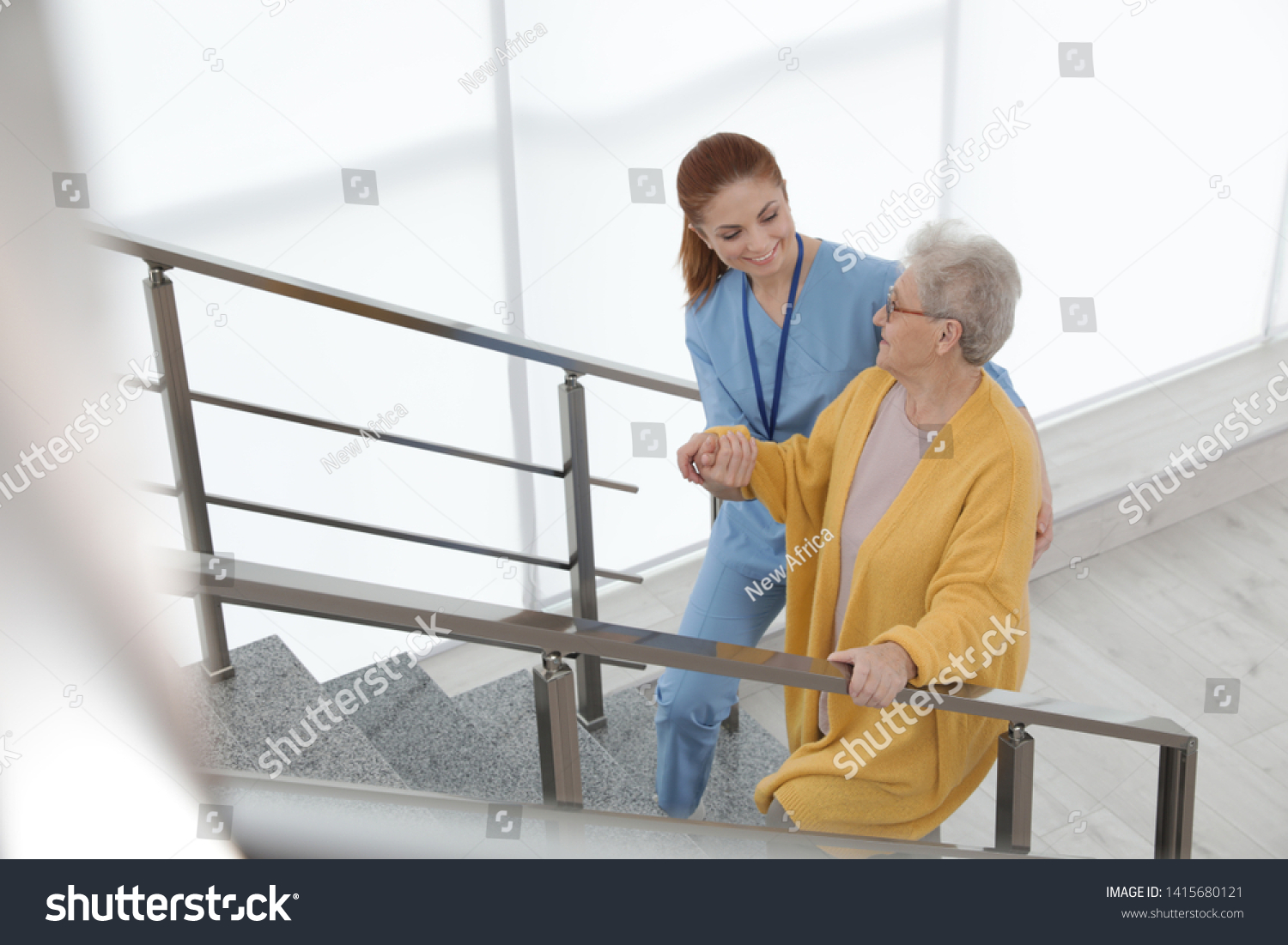Nurse assisting senior woman to go up stairs at hospital #1415680121