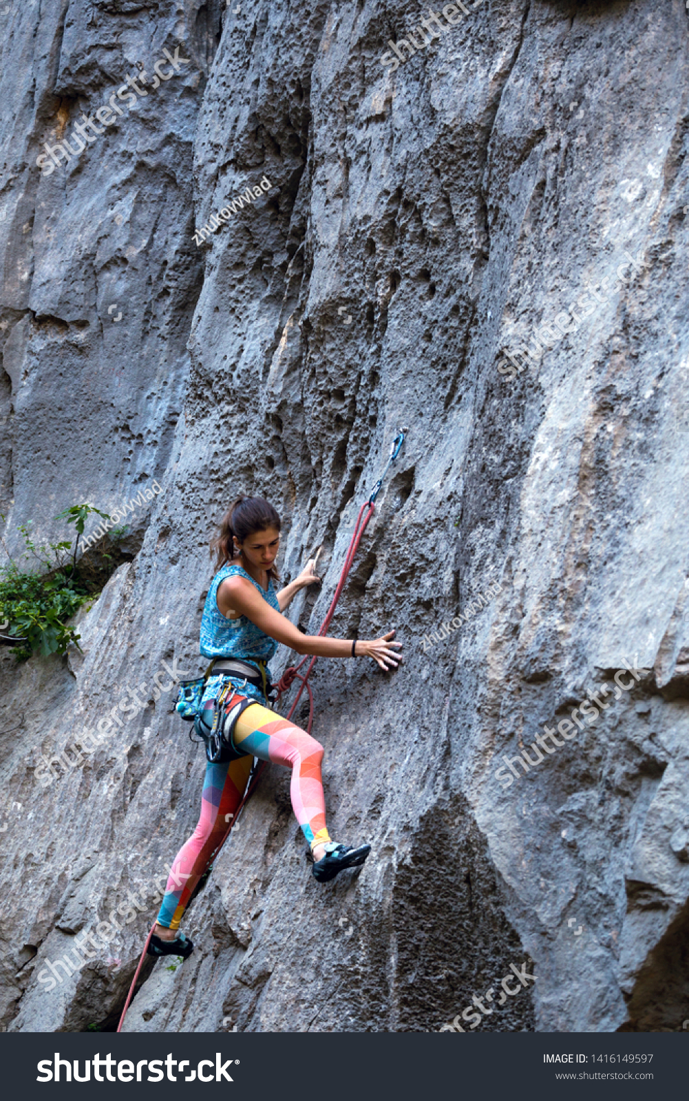 Climber overcomes challenging climbing route. A girl climbs a rock. Woman engaged in extreme sport. Extreme hobby. #1416149597