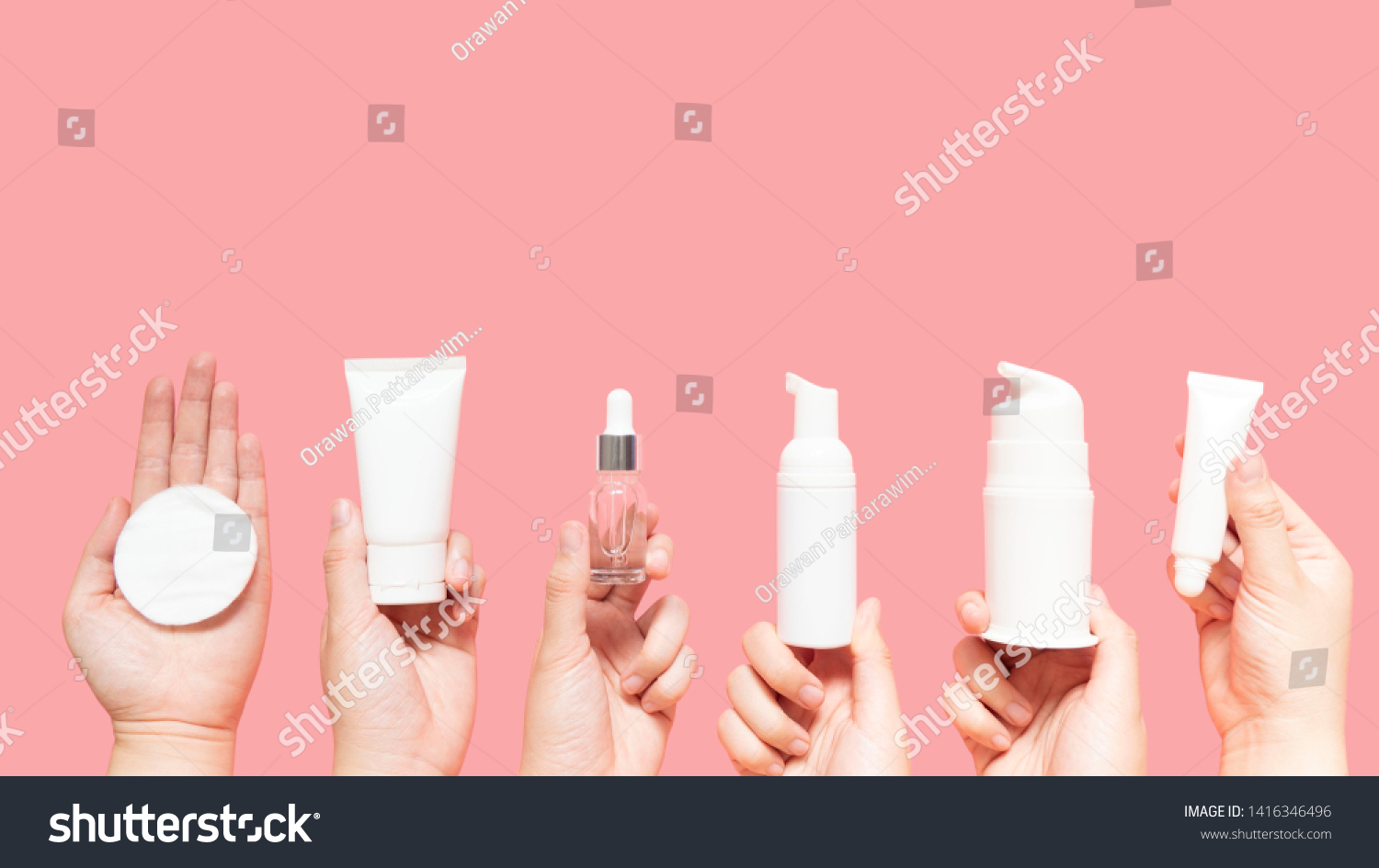Skincare routine step for healthy skin - Woman hands holding facial cotton pad, foam, essential oil, serum, lotion and eye cream packaging on pink background. Beauty and cosmetic concept. Copy space. #1416346496