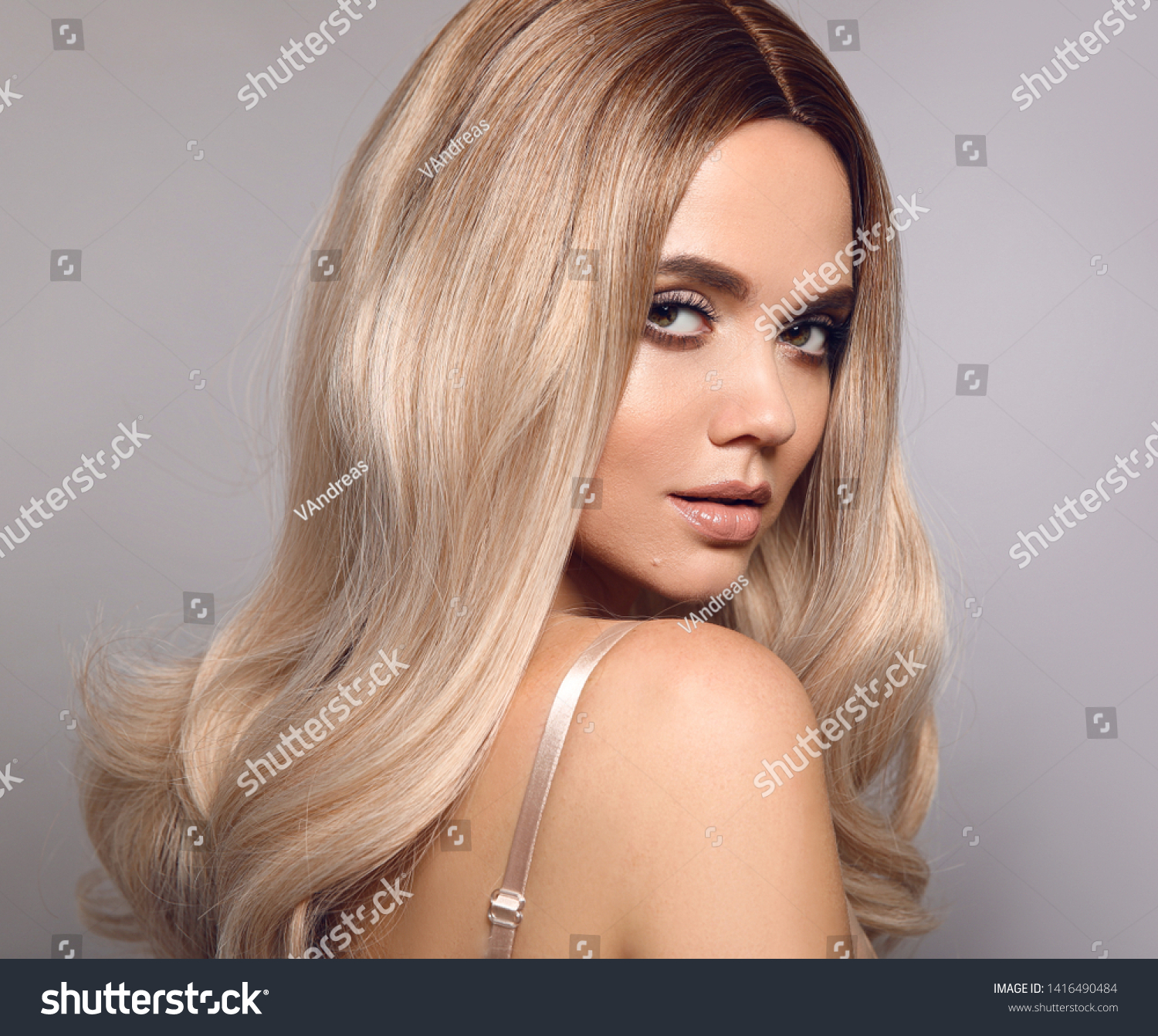 Ombre blond shiny hair. Beauty fashion blonde woman portrait. Beautiful girl model with makeup, long healthy hairstyle posing isolated on studio grey background. #1416490484