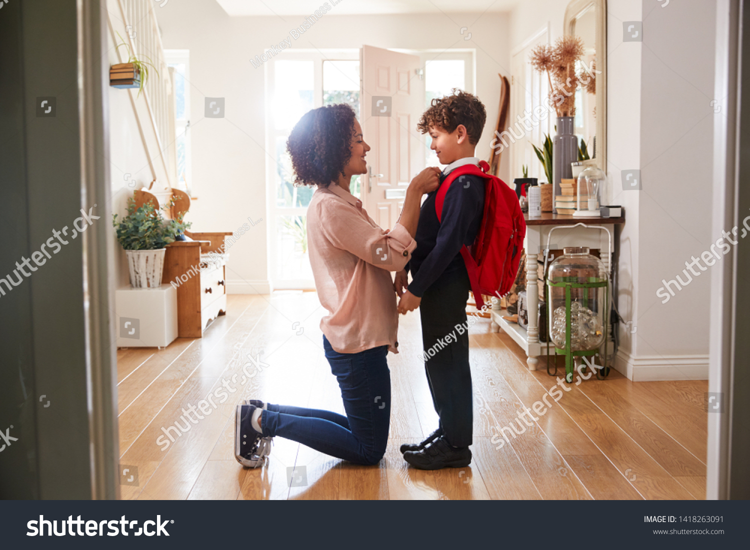 Single Mother At Home Getting Son Wearing Uniform Ready For First Day Of School #1418263091