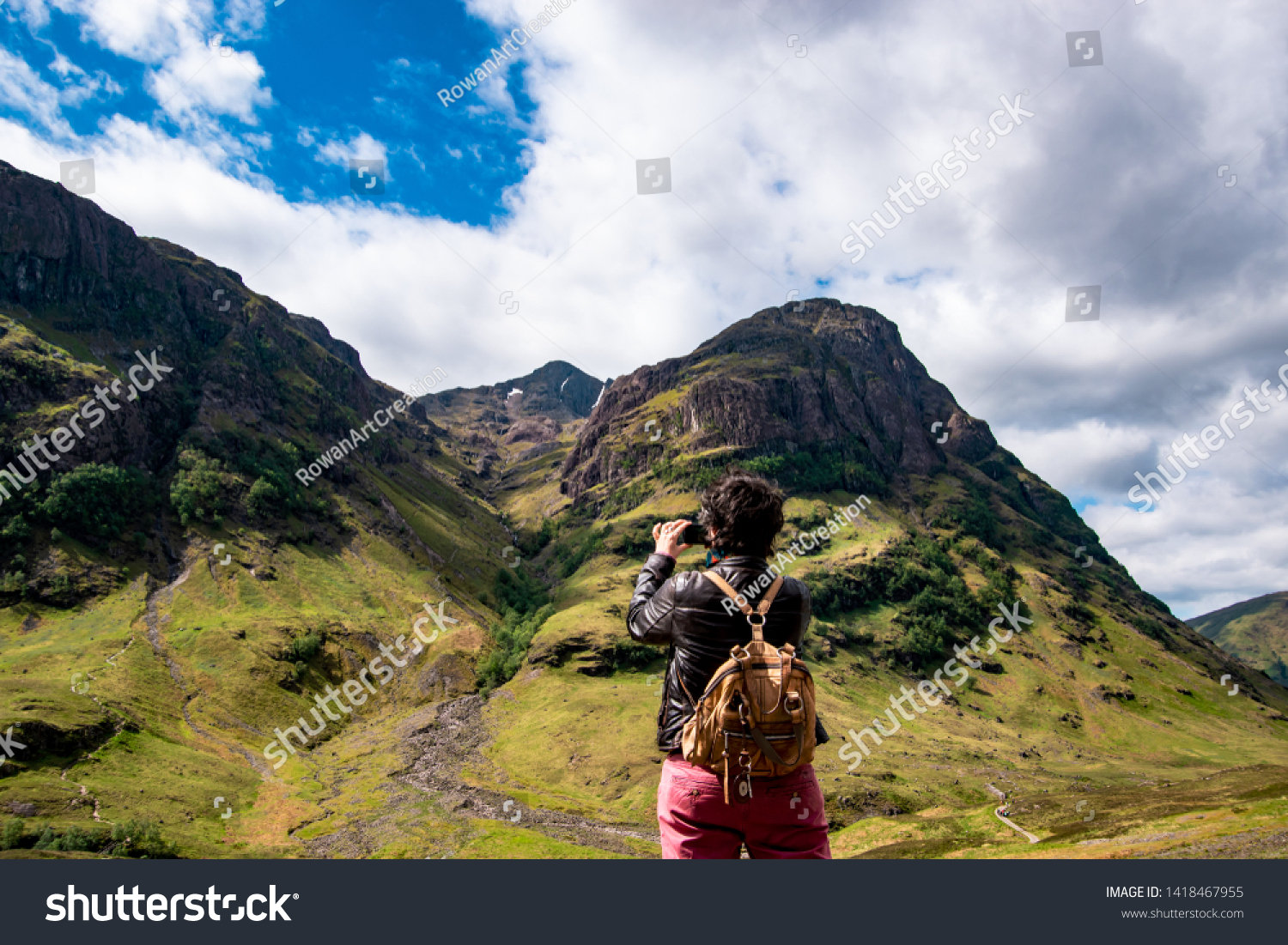 Panoramic view of the Three Sisters in Glencoe with a tourist. Scotland, UK. #1418467955
