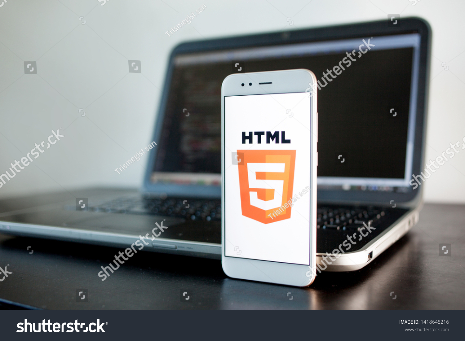 SAINT PETERSBURG, RUSSIA - MAY 16, 2019: Mobile application development, HTML5 programming language for mobile development. Workplace of programmer, tester, laptop, illustrative editorial #1418645216